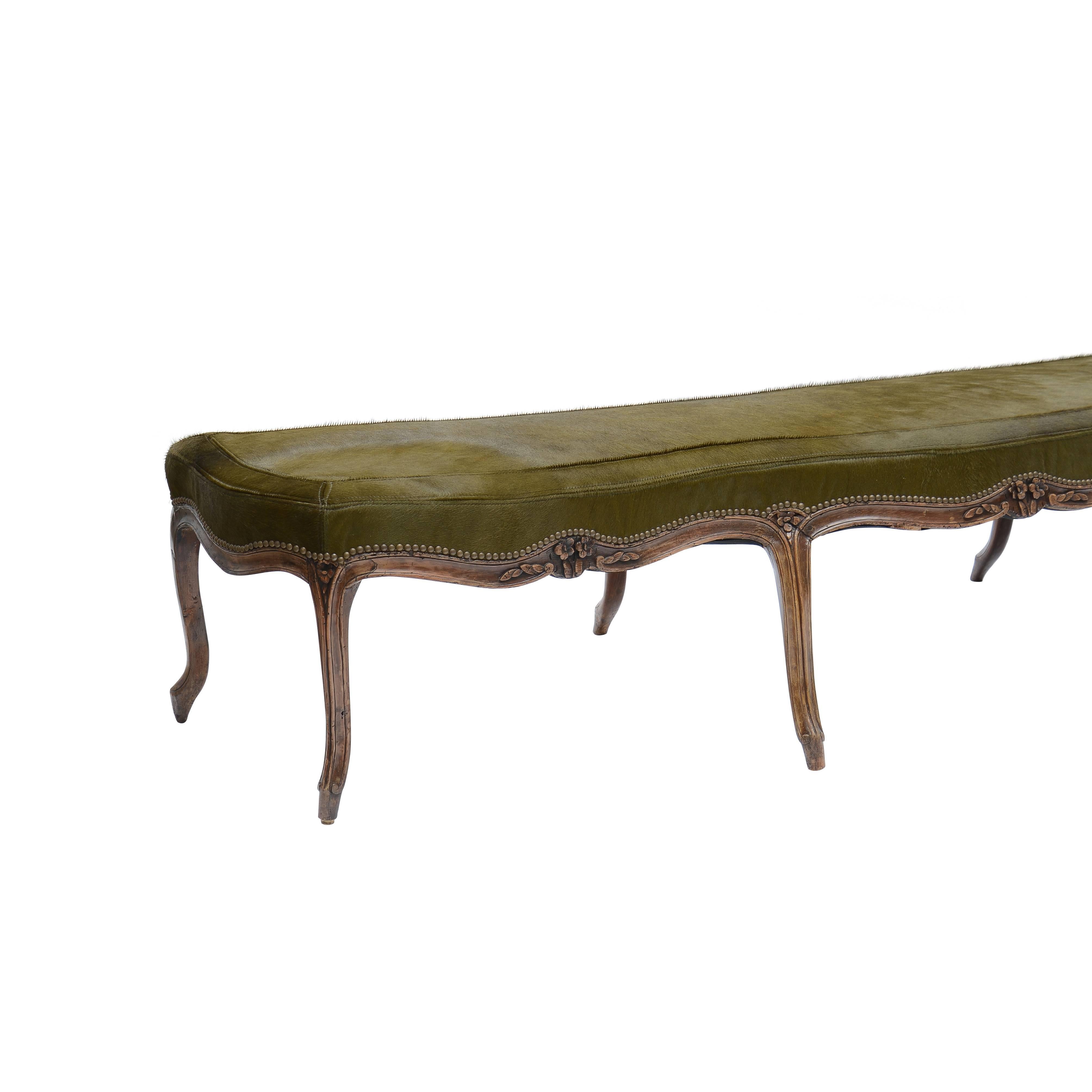 Louis XV style carved wood bench on cabriole legs upholstered in moss green hair on hide with saddle stitch detail.