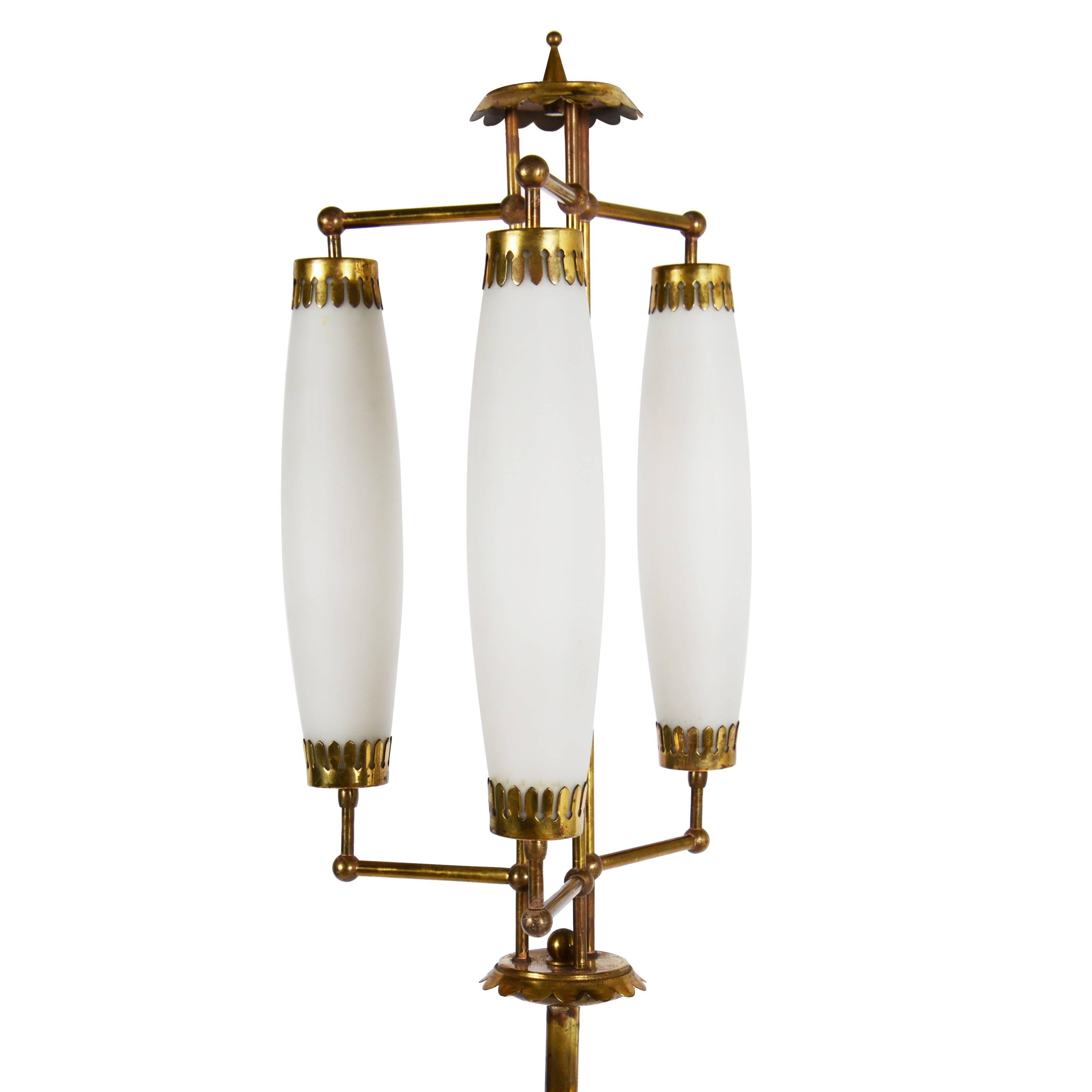 Brass floor lamp with three ovoid lantern diffusers on tripod base.
 