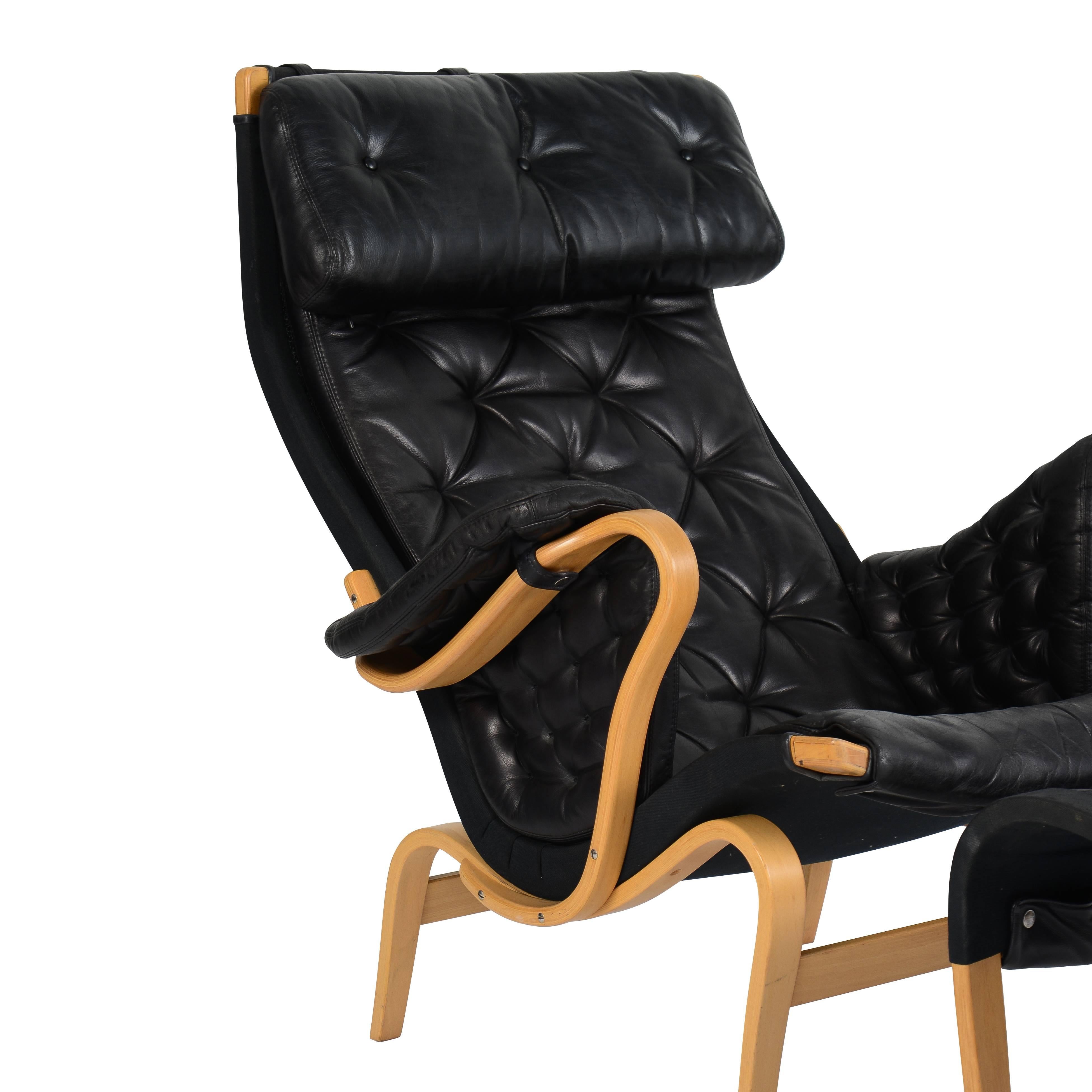 Bent beechwood armchair and ottoman upholstered in black leather.
         