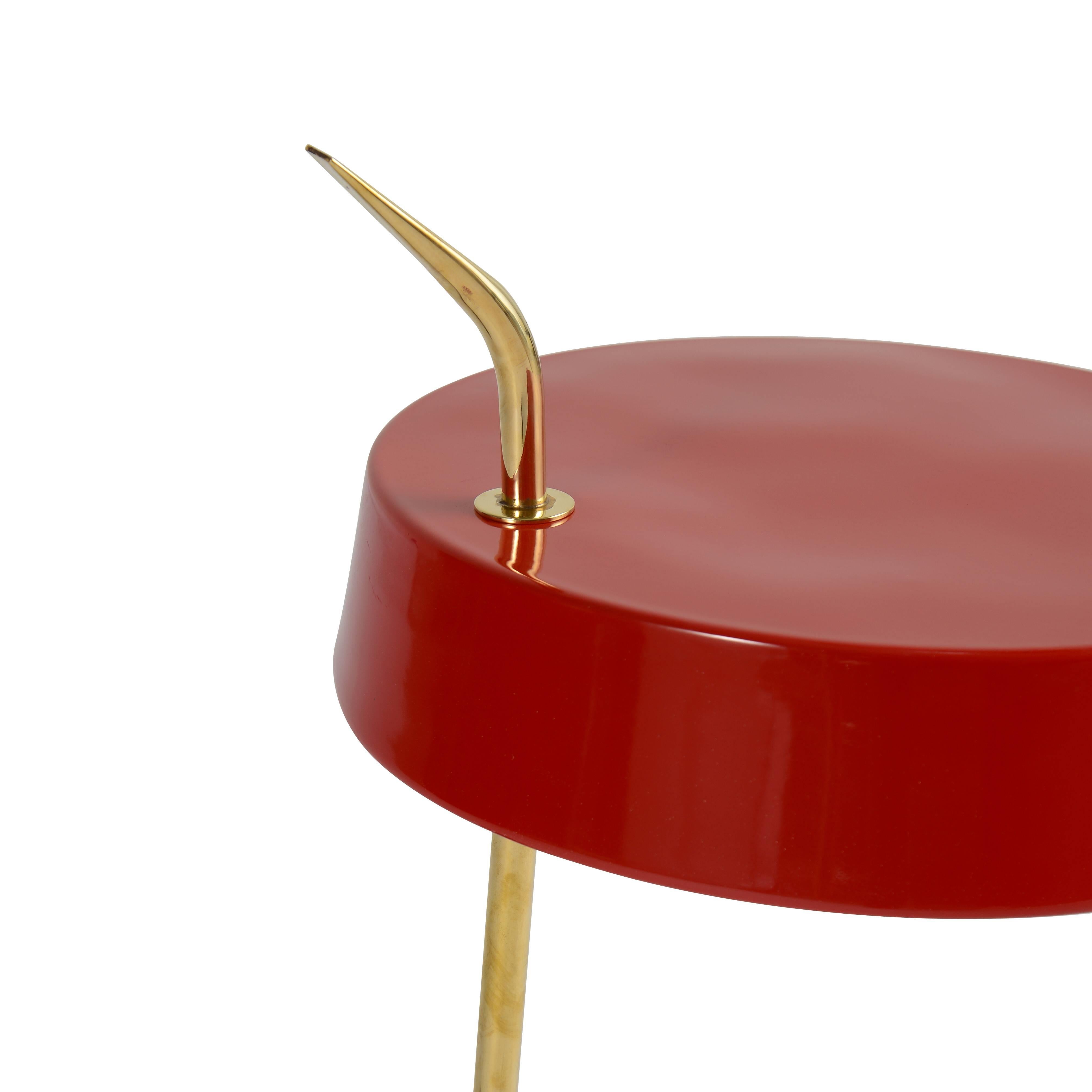 Red enameled desk lamp with brass fittings on marble base.