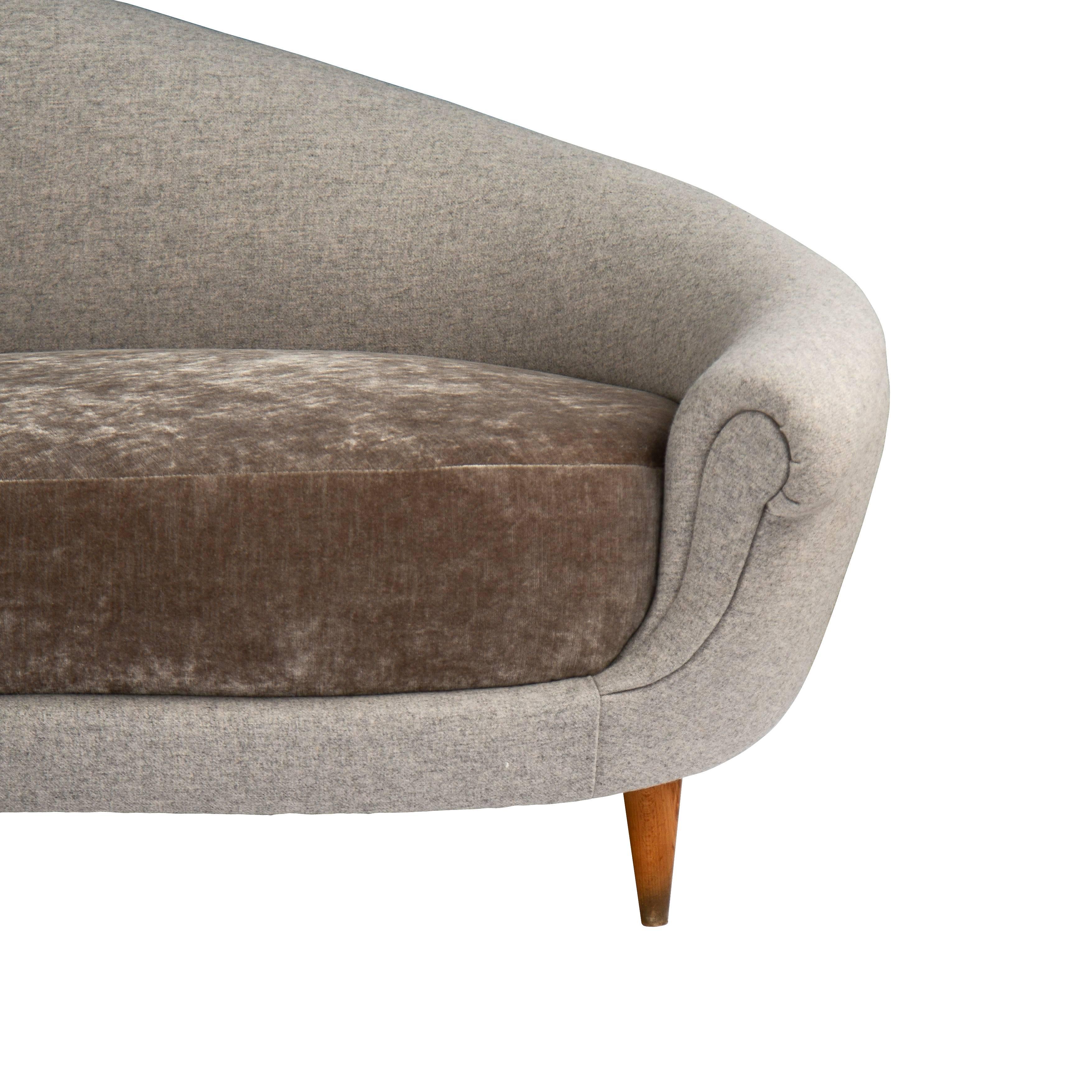Curved sofa on tapering wood legs.
  