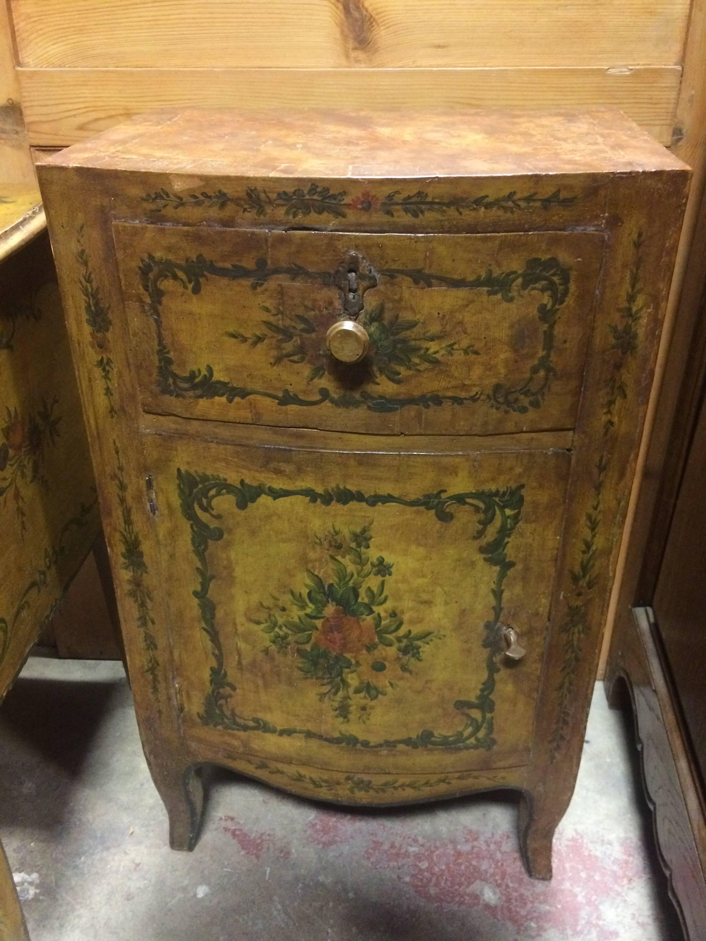 18th century Venetian commode yellow lacquered pine with painted flowers and foliage, splayed legs.
TWO AVAILABLE
Drawer over convex curved door.
Greens, yellows, rose and cream colors. 

(Nightstand, side table, end table).