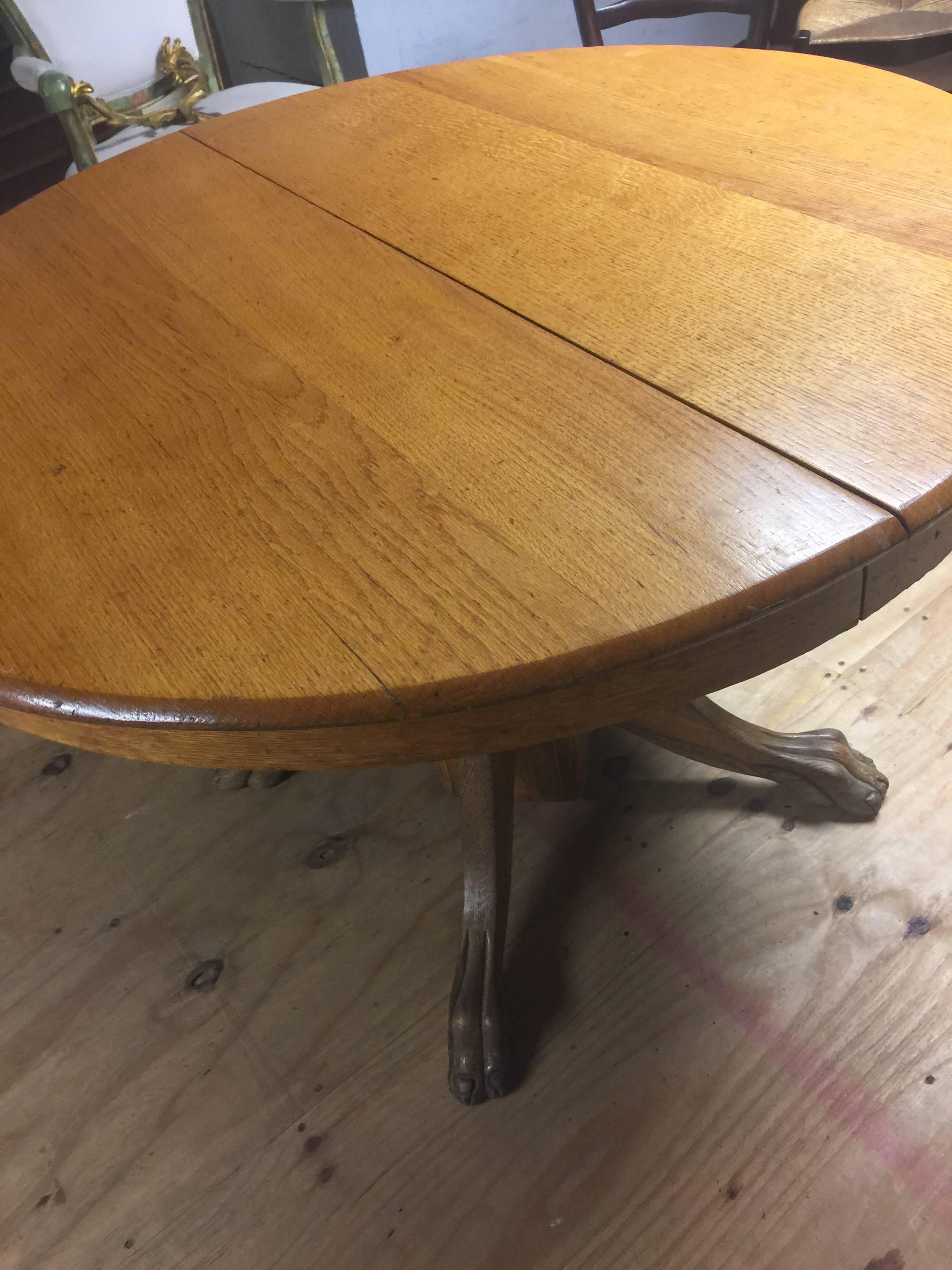 Late 19th century American oak dining table extendable with claw feet 
Parlor table, center table.
25" clearance.