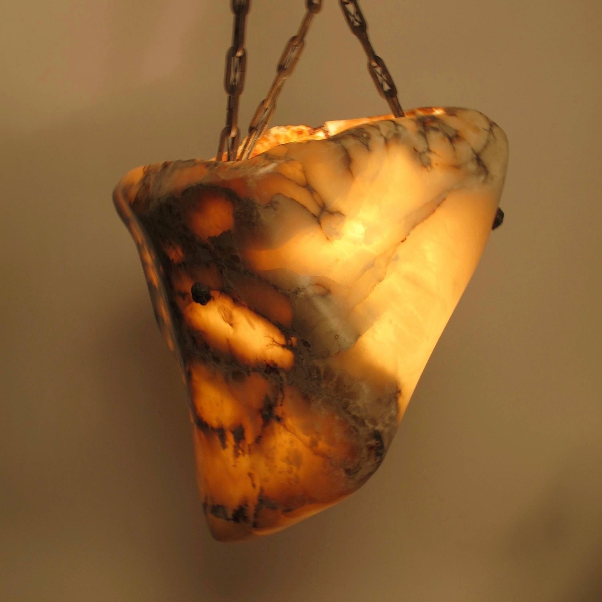 Artisan hand carved Alabaster Hanging Light Fixture with 19th. Century Bronze mounts woven knot chain and floret bronze canopy.  Interior wired with 3 standard base sockets.  The Organic Shape Alabaster Light is recently hand carved and accented