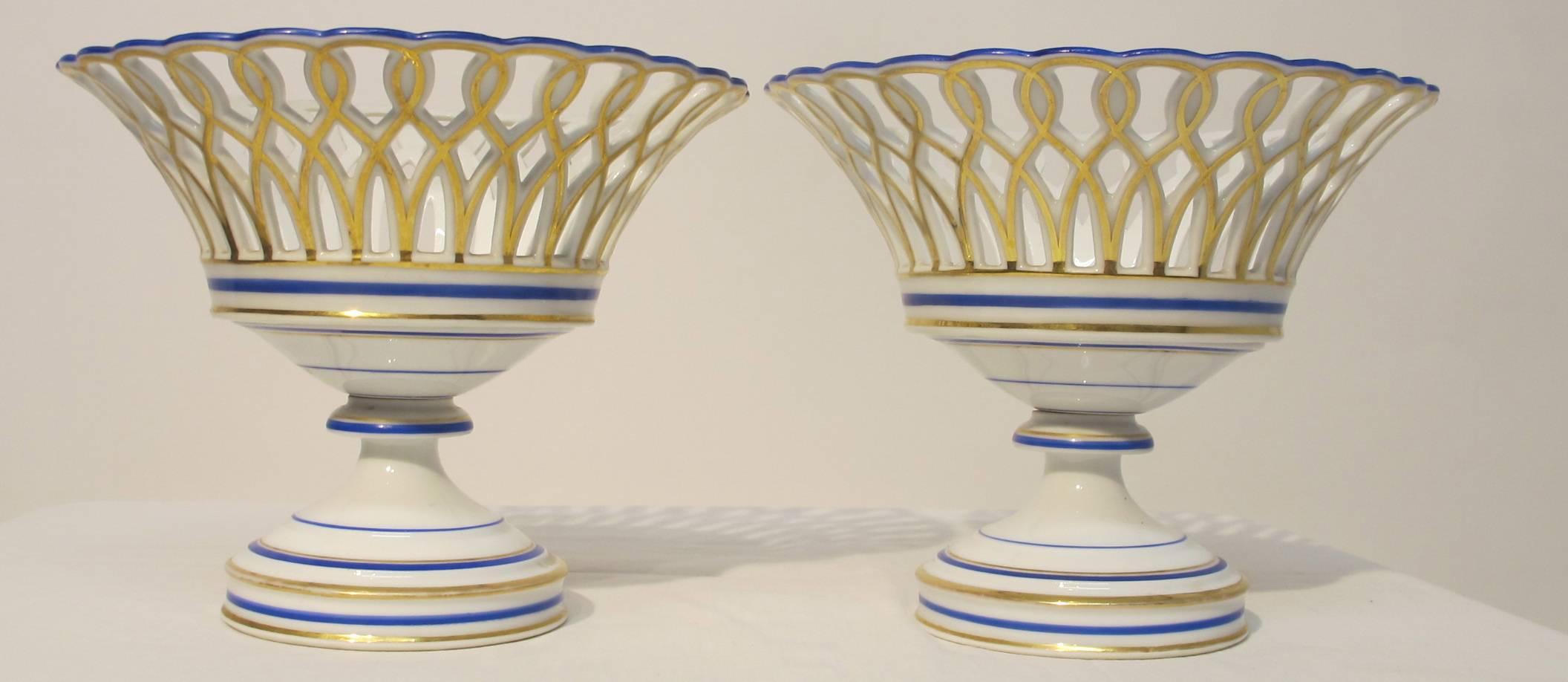  Old Paris porcelain reticulated baskets highlighted with gilt and blue banding standing on circular stepped bases, Paris Porcelain, French, circa 1860.