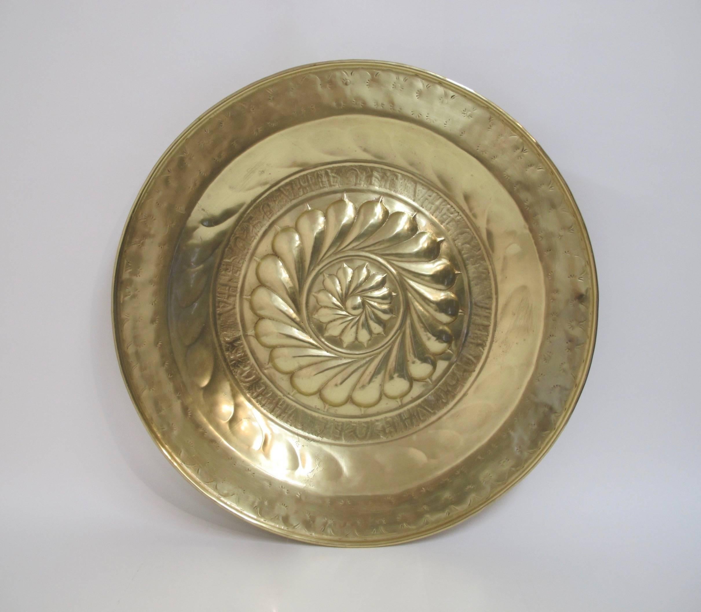 A 17th century or earlier brass alms dish or alms plate.