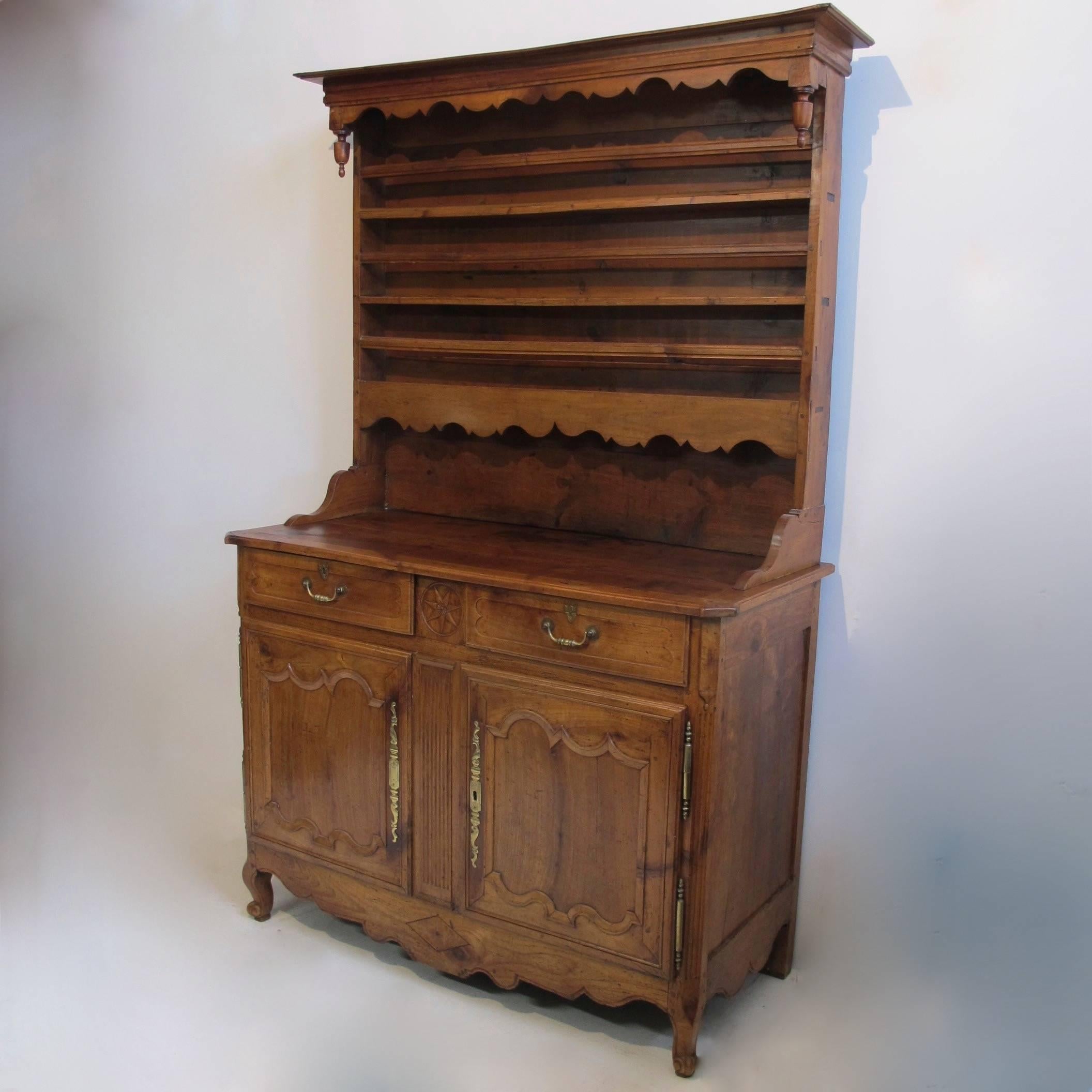 Hand-carved solid cherrywood buffet with two drawers over a pair of recessed paneled doors sitting on scroll feet, and having a secret compartment between the two drawers. Has original brass hardware and period key. The plate rack is not attached so