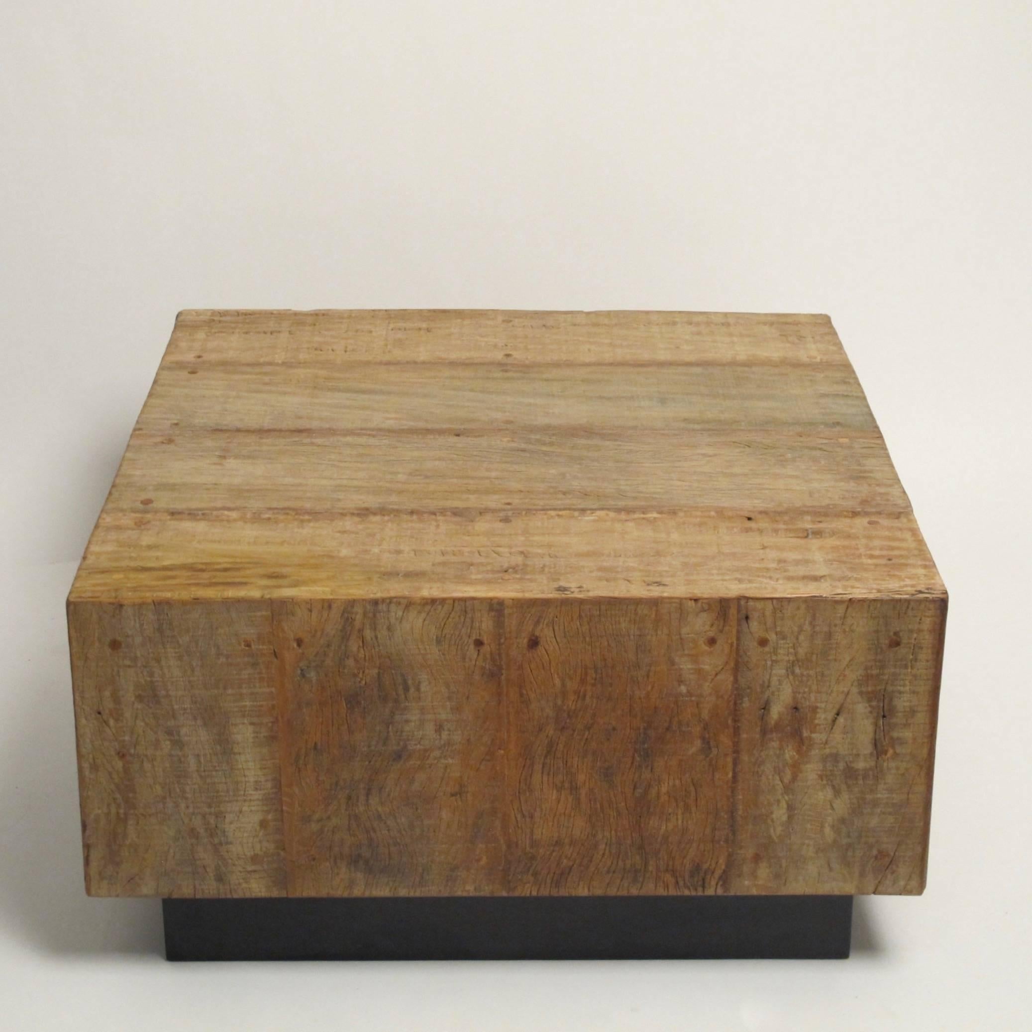 Cube shaped weathered wood coffee table on black wood base in the manner of Milo Baughman.