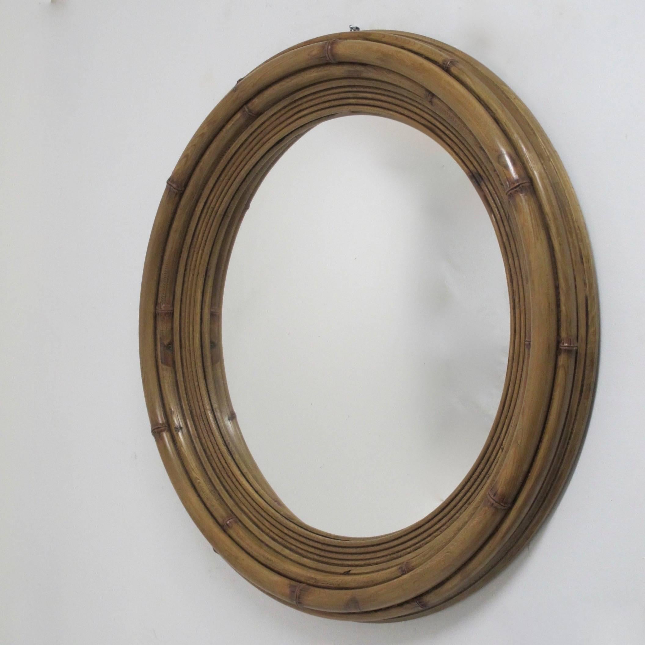 A large carved pine wood frame (made to look like bamboo) with convex mirror.