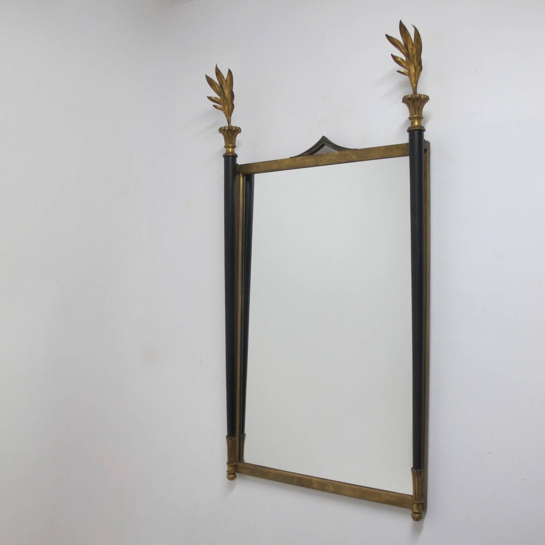 Neoclassical style iron mirror with gilt tole frawn finials and ebonized columns. Having the original Palladio paper label on the back. Italy, circa 1960s.