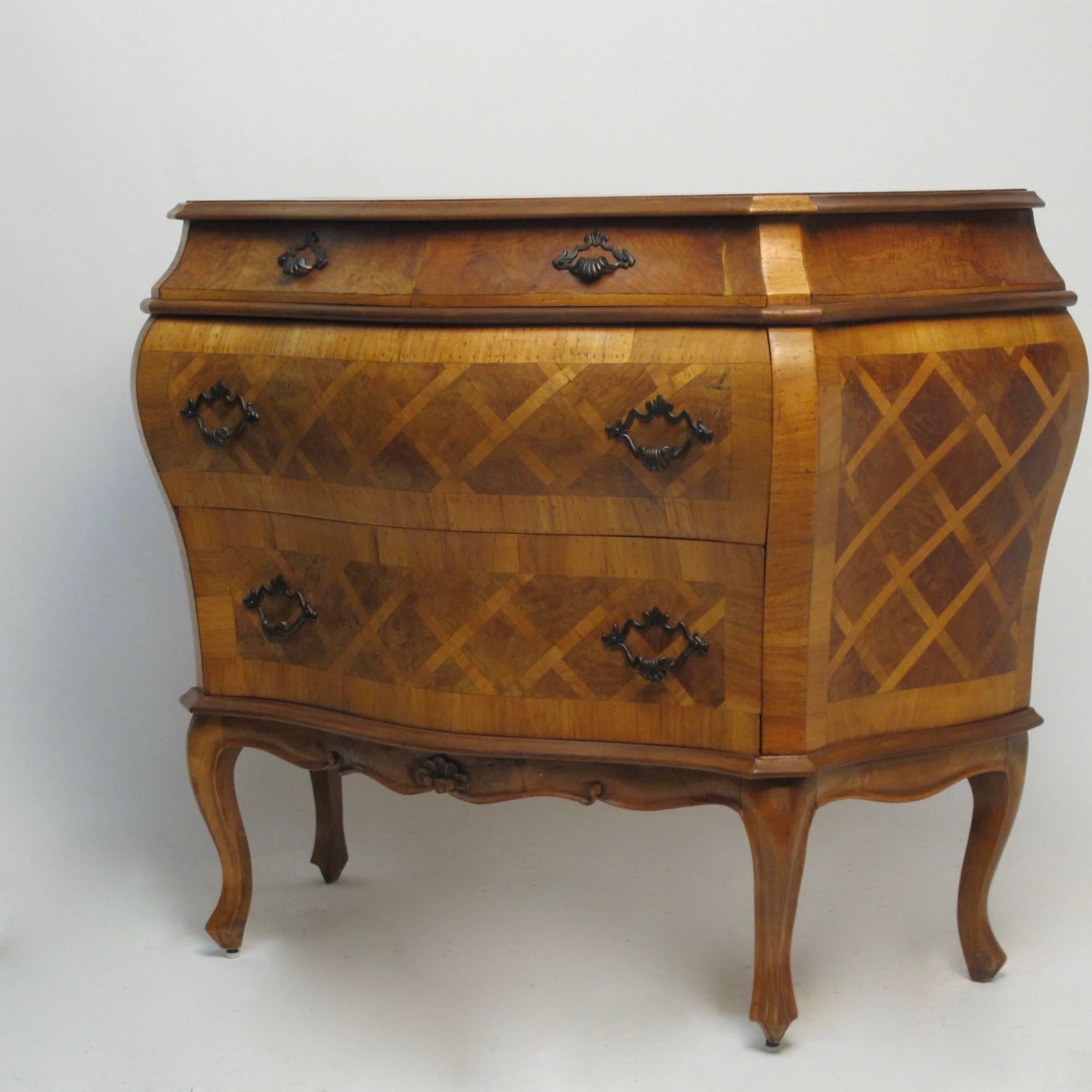 A shapely bombe style three drawer commode or chest with inlaid crosshatch parquetry design.