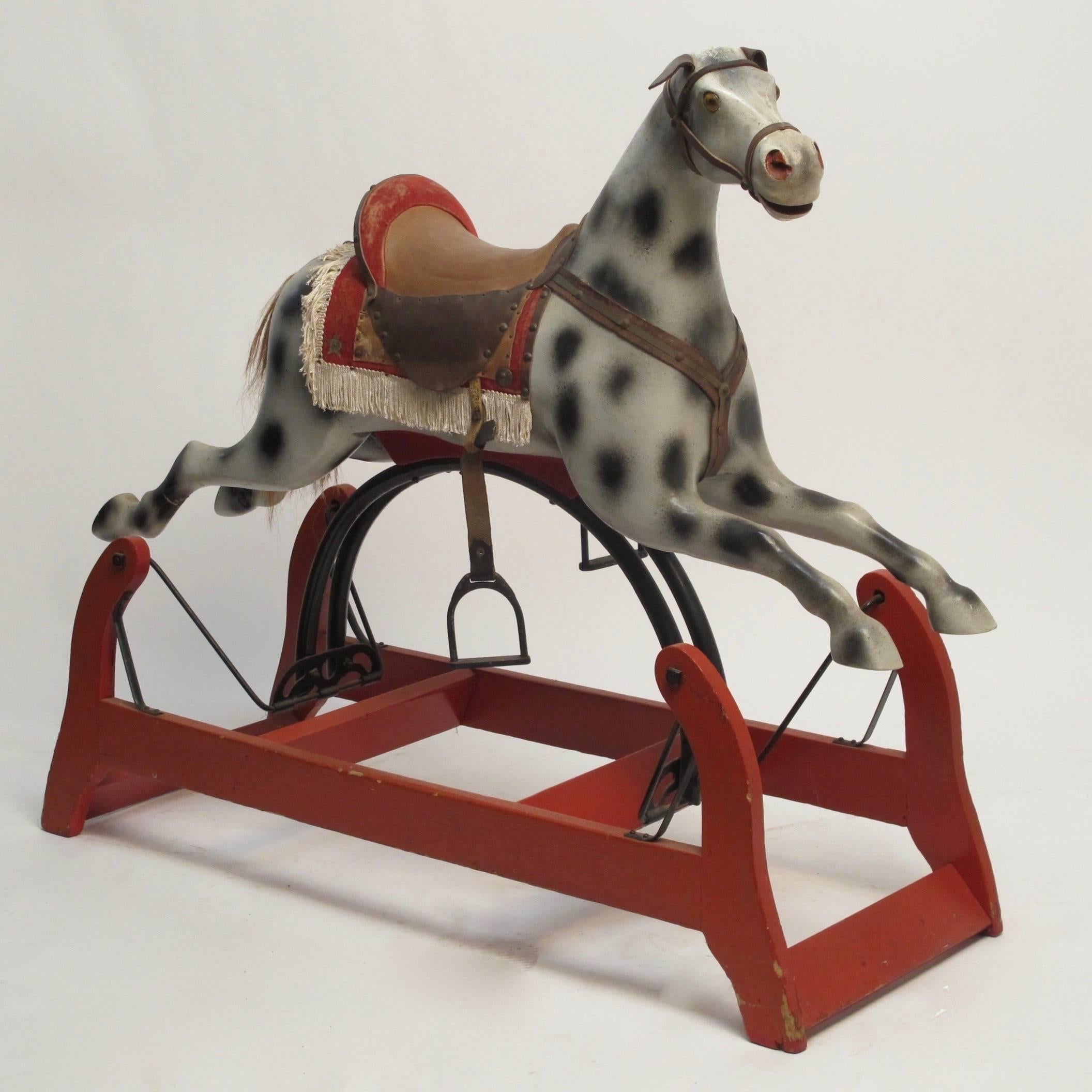 Charming old rocking horse. Painted wood, with leather and fabric saddle and iron stirrups. American, late 19th century-early 20th century.