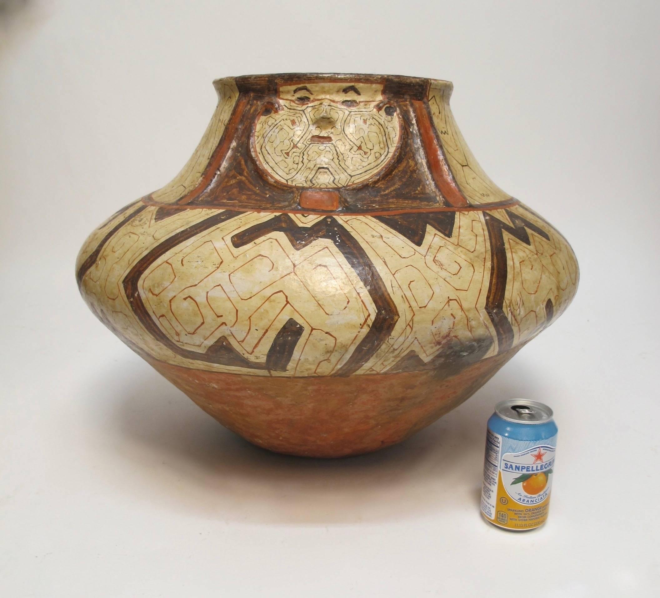 Une urne ou un récipient en poterie polychrome Shipibo plus ancien et inhabituellement grand. Visage joliment sculpté au niveau du cou avec un corps bien arrondi. Taches générales correspondant à l'âge et à l'usage tribal:: Pérou:: début ou milieu
