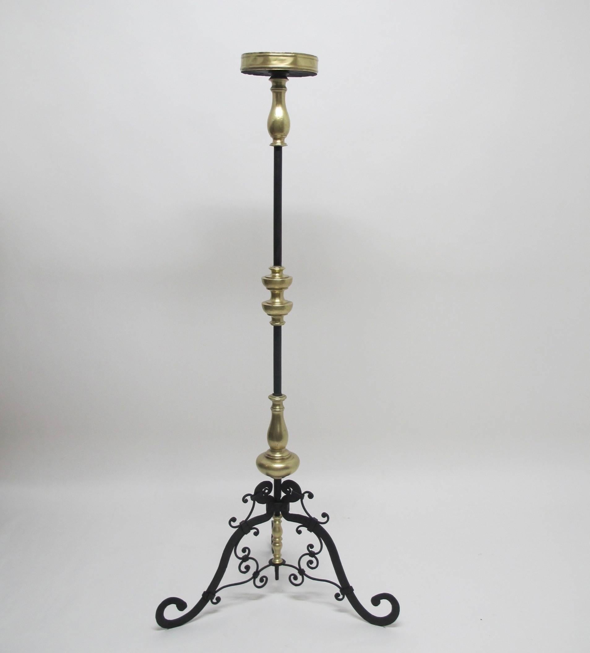 Brass and wrought iron candle torchiere standing on three splayed legs with scrolling accents. Italy, 17th century.