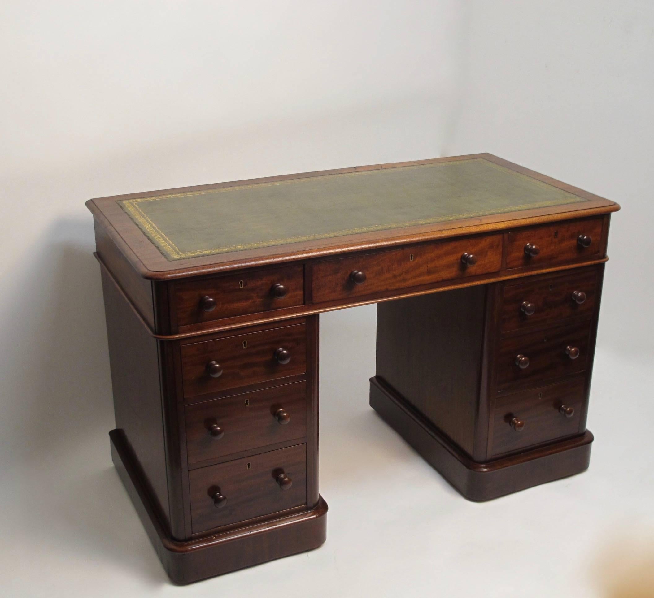 Small scale mahogany double pedestal desk with inset green leather writing surface accented with gold tooling, the pedestals having graduated drawers. English, 19th century, circa 1880.
