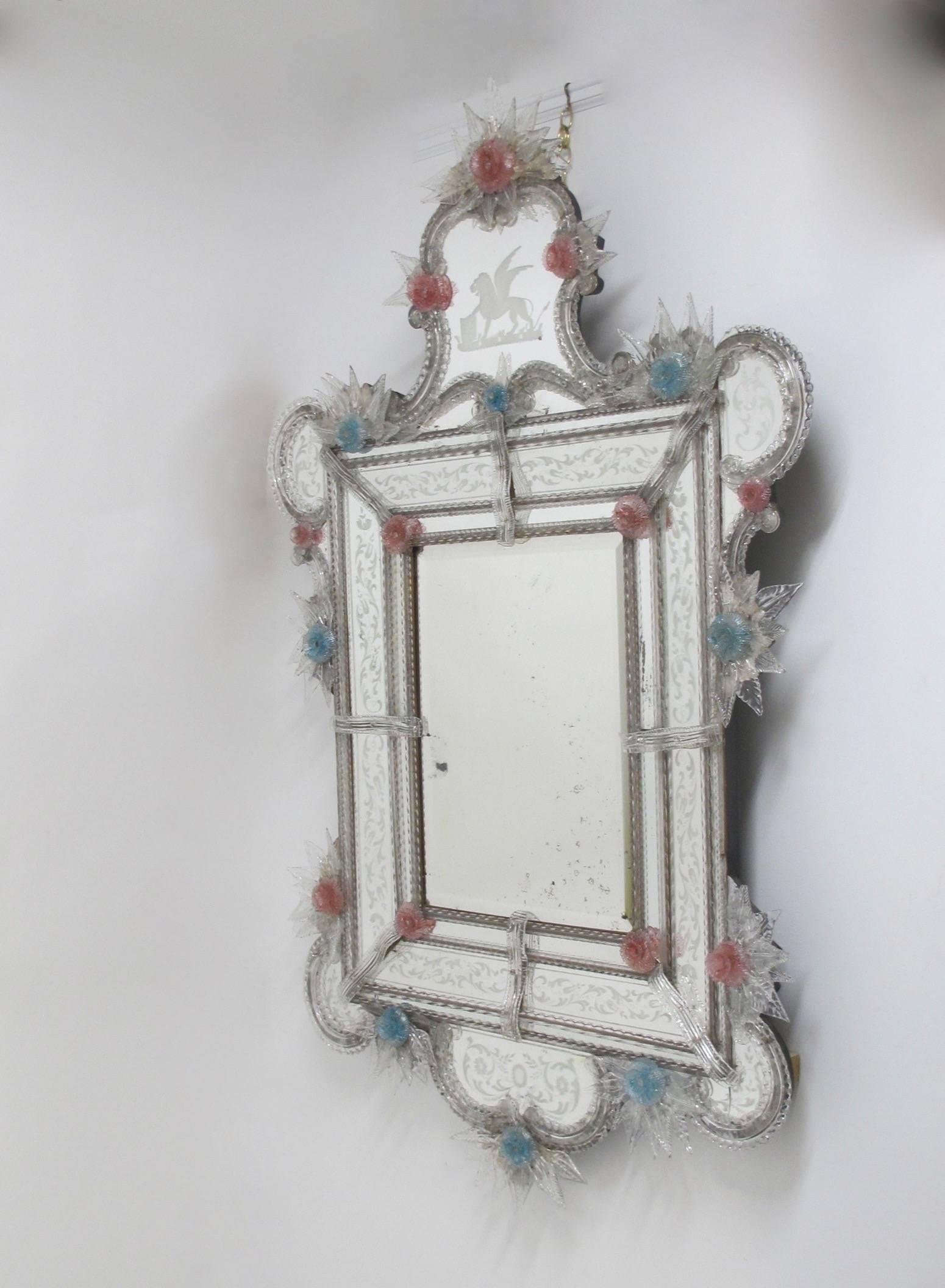 Wonderfully exuberant and fanciful large Venetian mirror with etched mirror panels and delicate pink and blue rosettes with clear leaves. There are some minor chips on the rosettes, the right bottom corner lobe has a crack in the glass. Italy, 19th