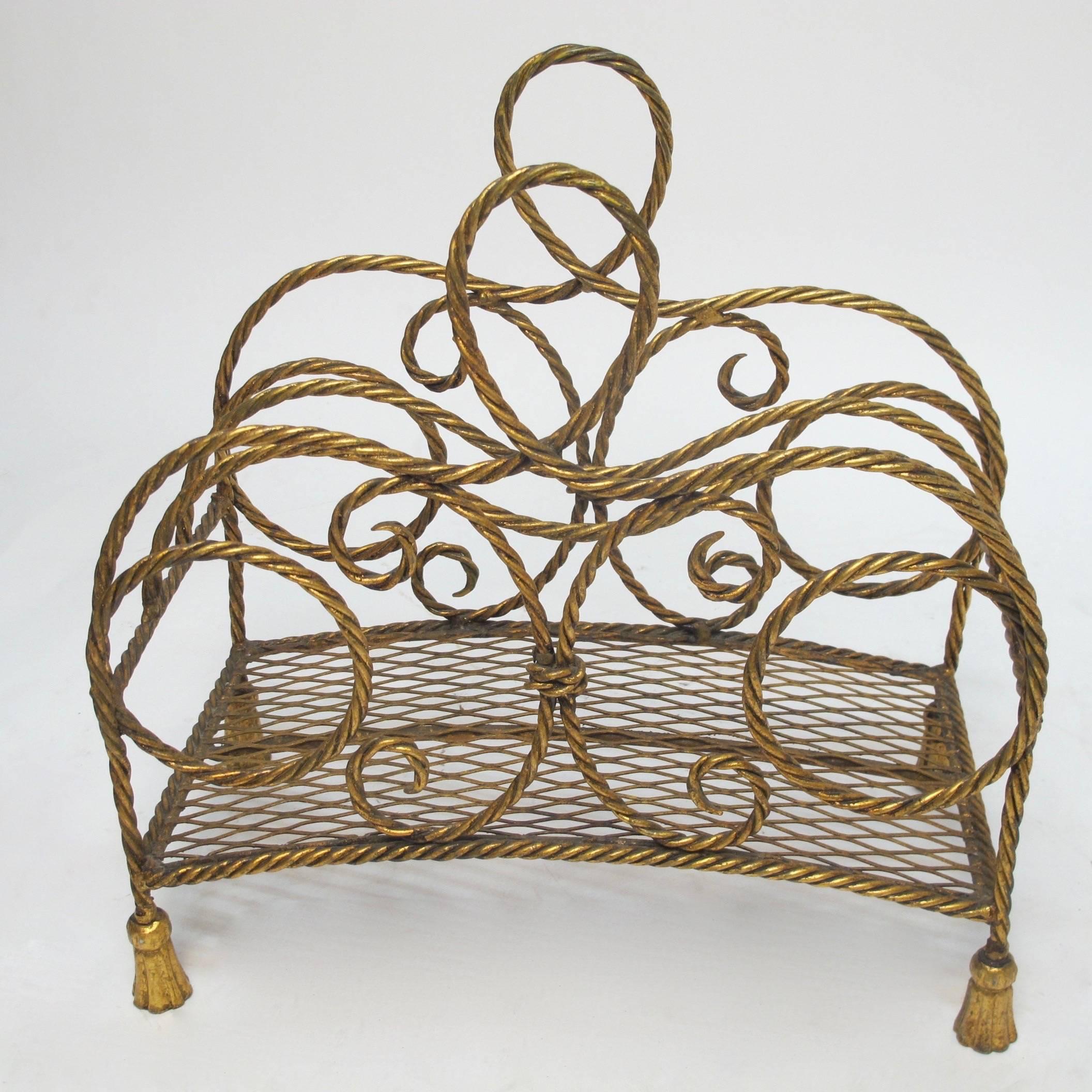 A vintage gilt metal magazine stand with a twisted rope design sitting on tassel feet, Italy, 1960s.