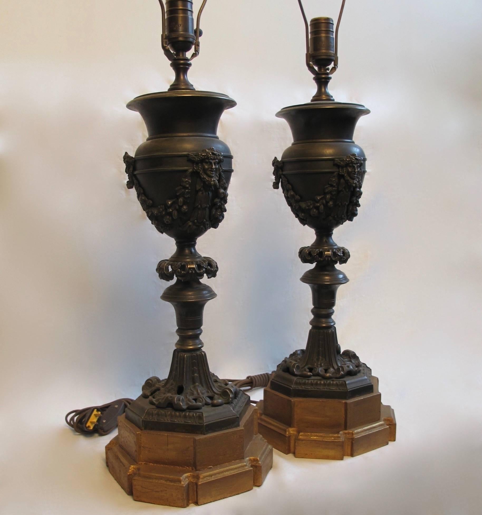 Fine quality bronze urns with masks and swags of fruit, now mounted and electrified as lamps. Continental, circa 1870.