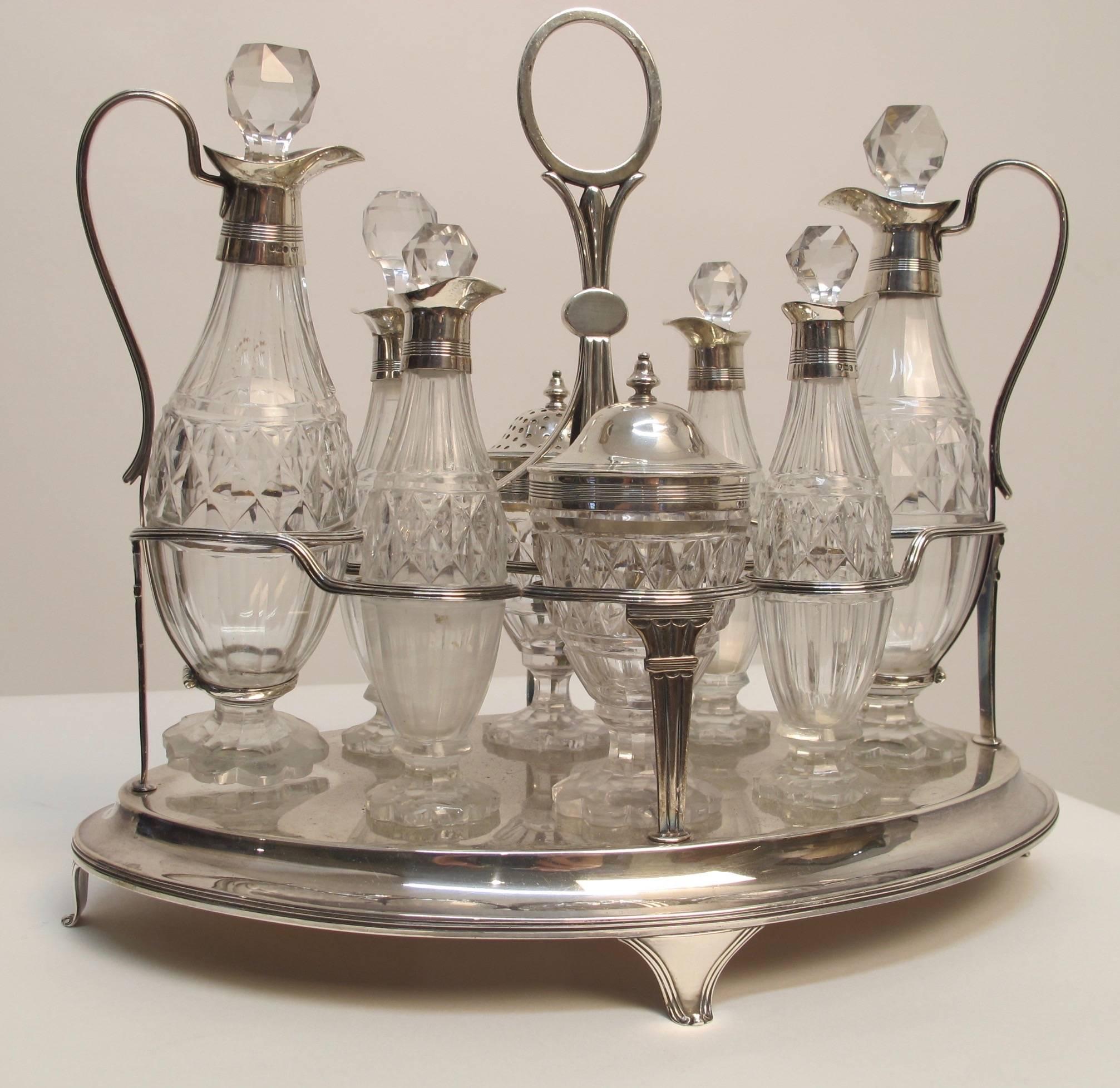 Elaborate glass and sterling silver cruet set, having original cut-glass bottles and jars. Sterling frame and sterling mounts, full hallmarks for London 1800, marked NH for Naphtali Hart.