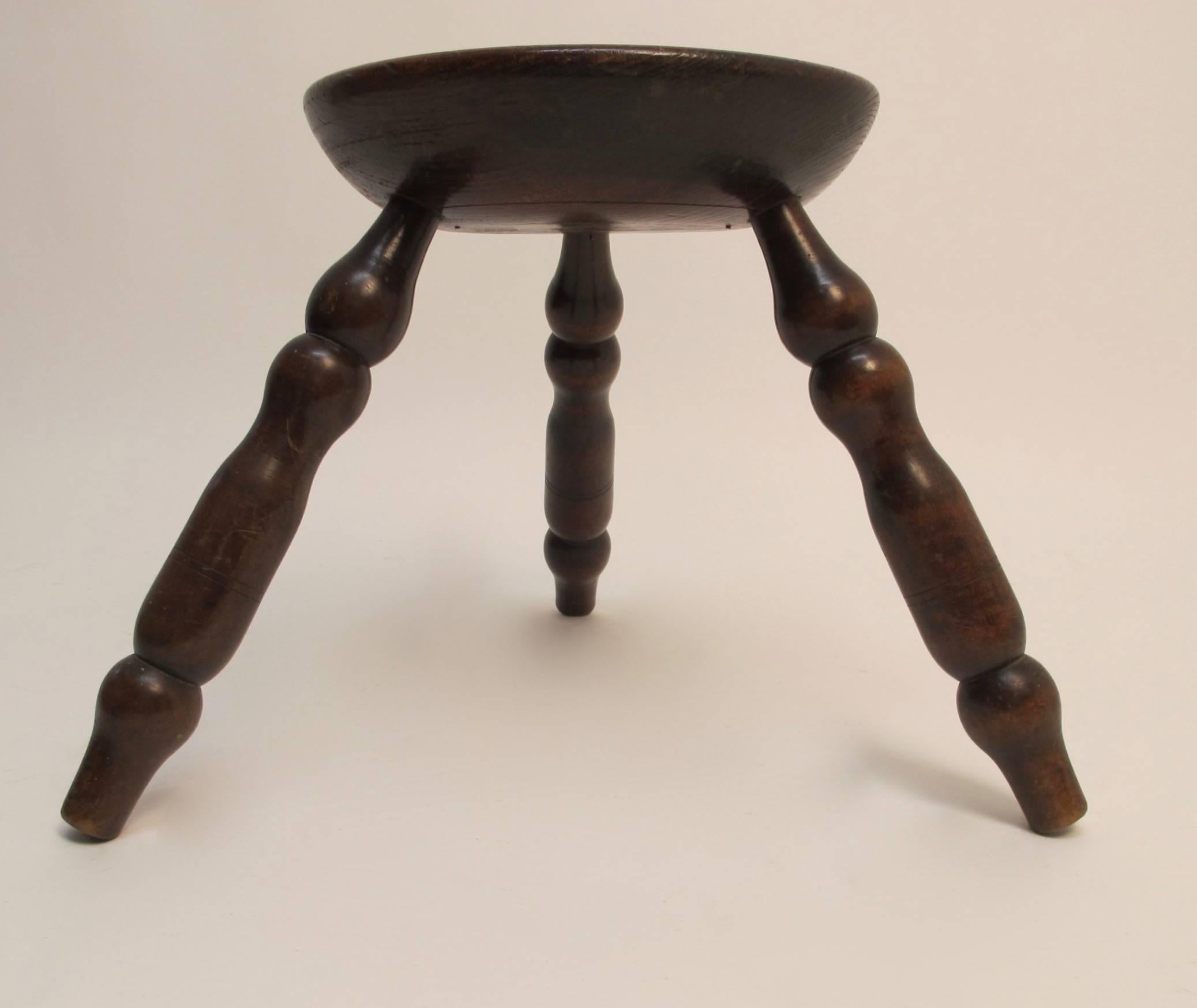 An unusual oak stool with three splayed legs, England, early 19th century. Seat diameter is 12 inches, leg diameter is 18 inches.