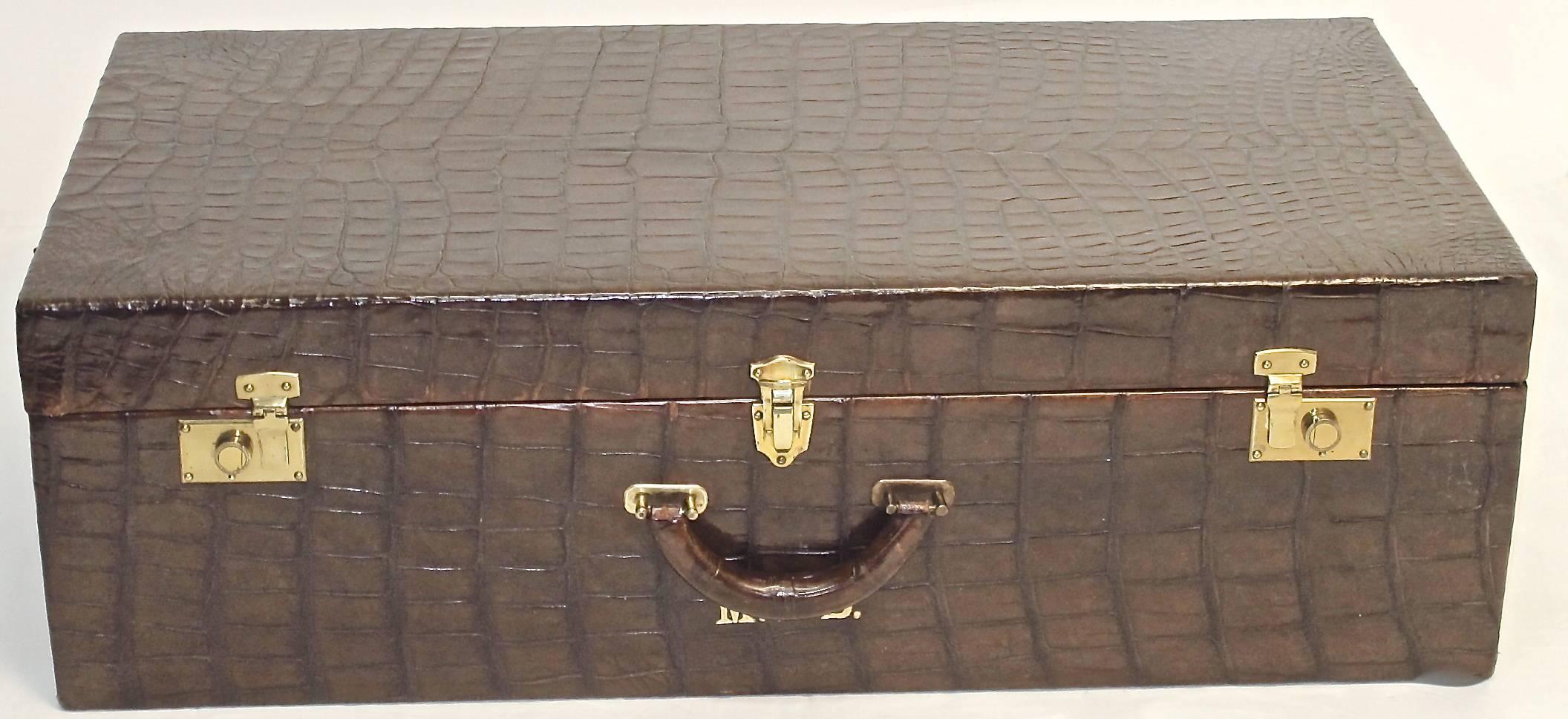 Custom alligator suit case from the 1920s or 1930s. With embossed gilt initials. Both ends trimmed out with small brass-headed tacks. Interior lined with silk satin stripe fabric and a fitted interior with stretch pouches and lift out shelf. Brass