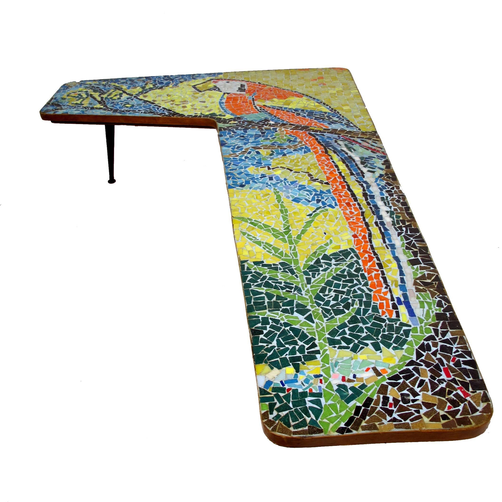 Handcrafted angular boomerang shape mosaic tile table with a large and colorful parrot. Tiles of ceramic and glass. American, mid-20th century.

