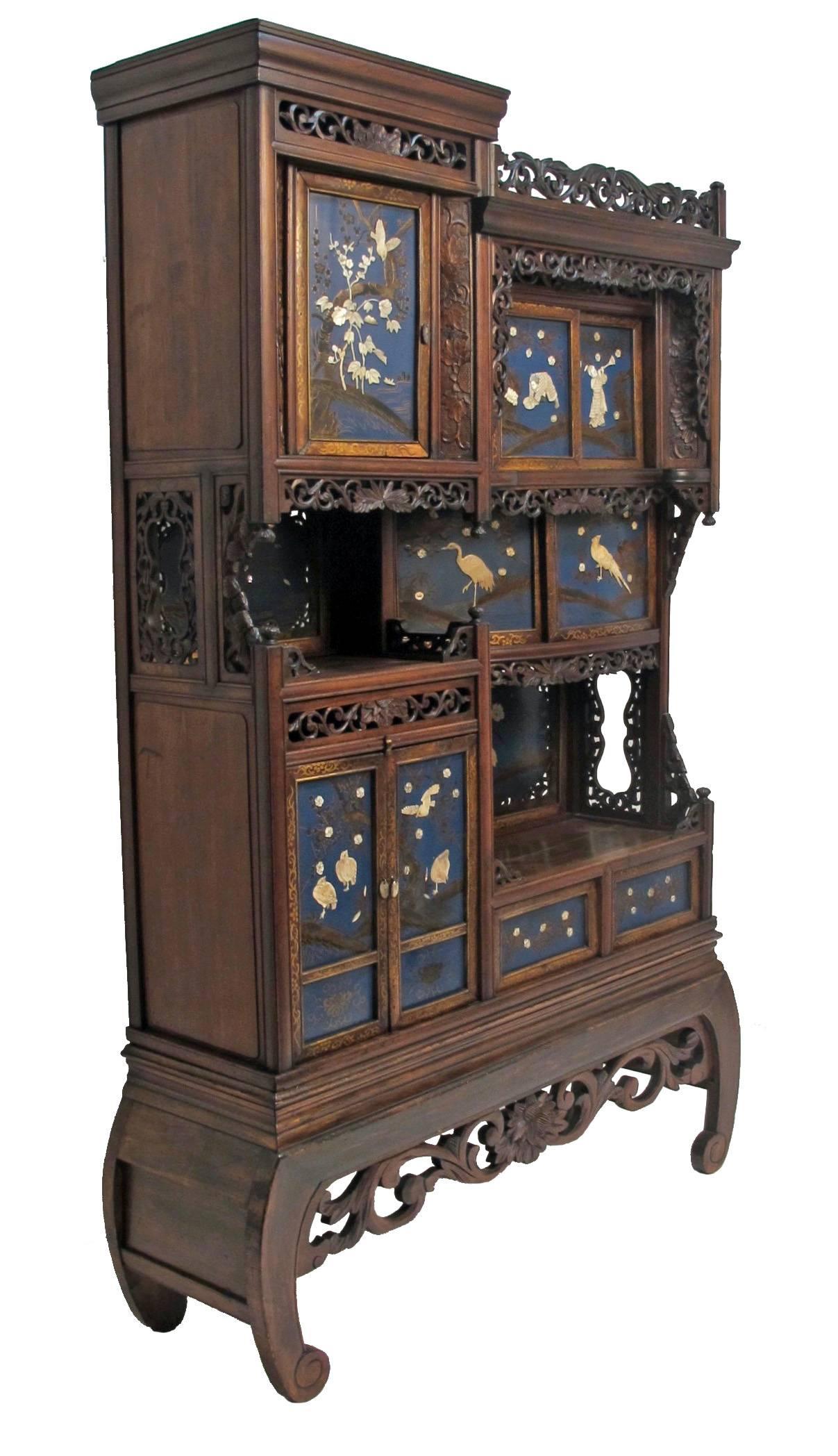 Beautifully carved wood cabinet or Etagere with bone and mother-of-pearl relief decoration on blue lacquer background. In remarkably good original condition, Japan, late 19th century.