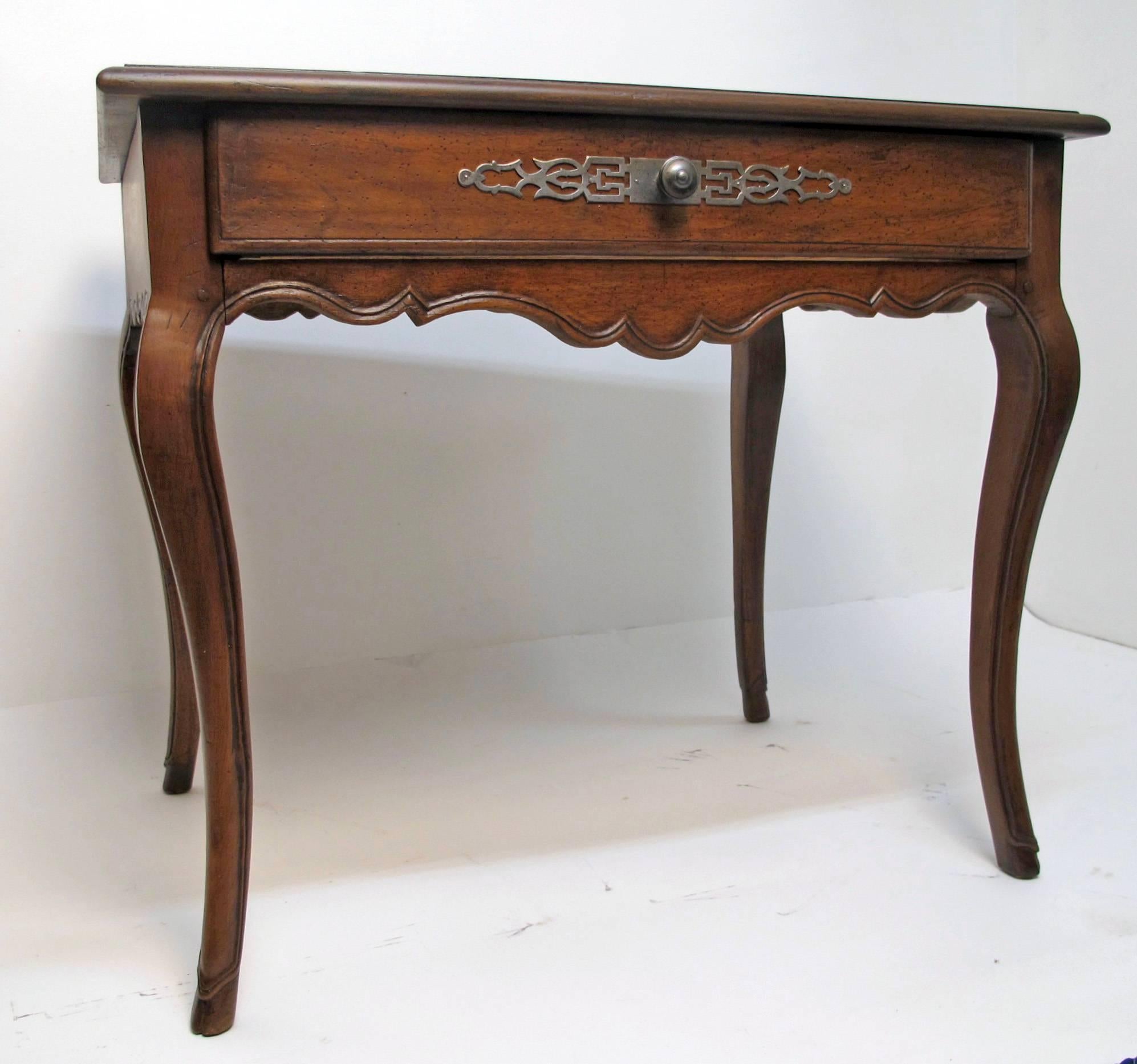 Ein Louis-XVI-Schreibtisch aus geschnitztem Nussbaumholz mit einer Platte aus braunem Leder mit Intarsien, die auf eleganten Cabriole-Beinen steht, die auf Hufeisenfüßen enden. Mit einer einzigen mittleren Schublade mit einer dekorativen Stahlplatte