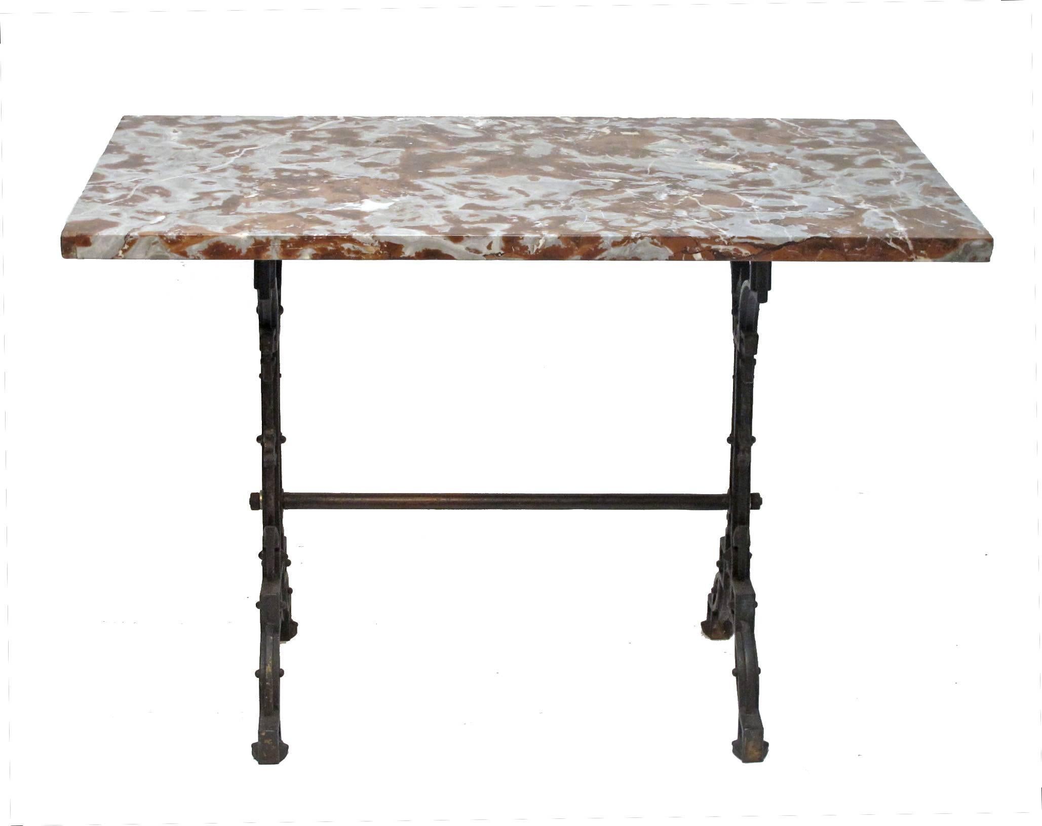 Cafe table with beautifully aged cast iron base and extraordinary fossilized rouge color marble top. France, late 19th century.