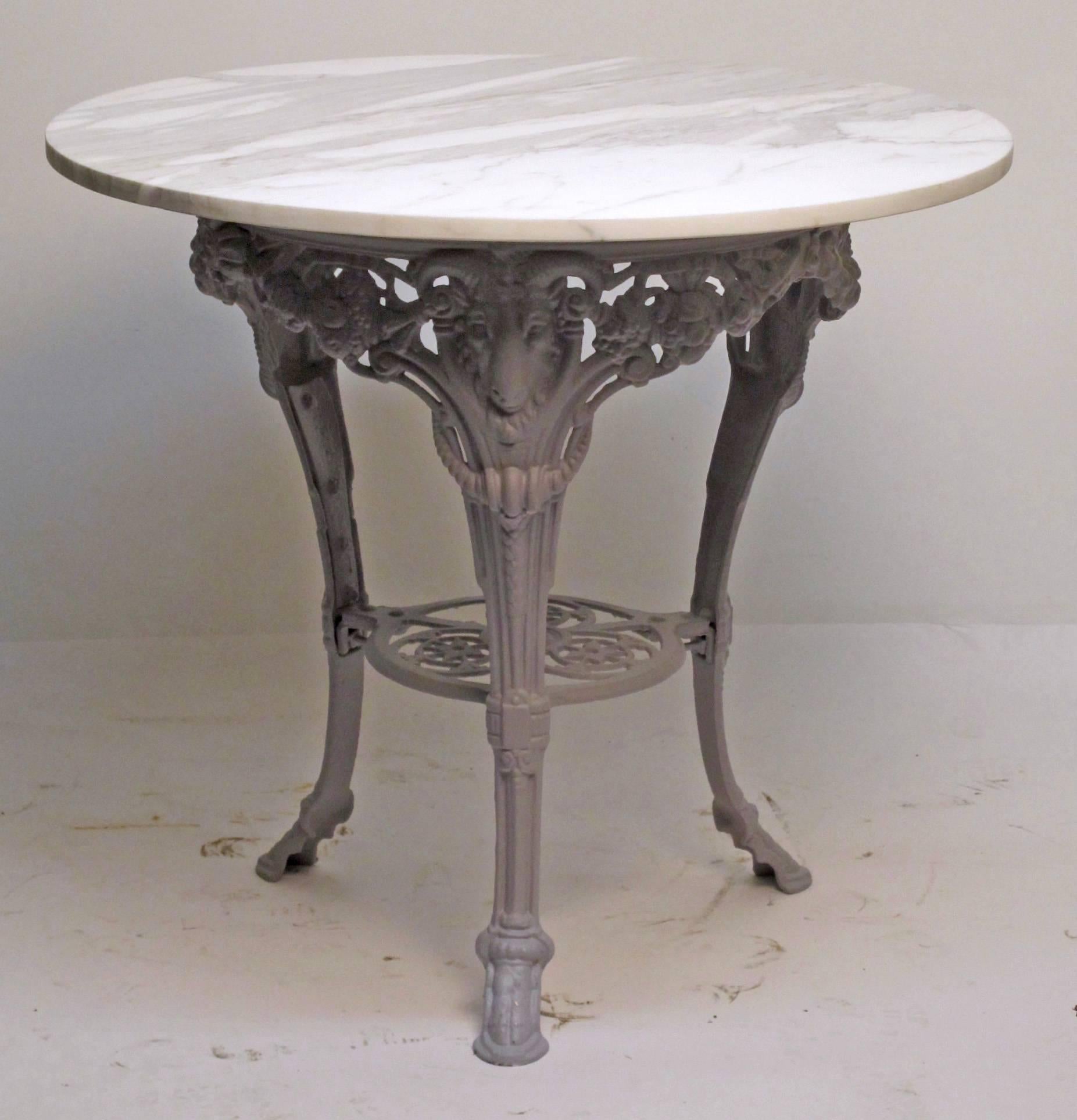 Cast iron base with marble top garden table. Currently primed in a flat gray color, ready for paint of desired color. There is an old professional repair to one leg, and a small minor loss on the stretcher (not visible and does not affect the