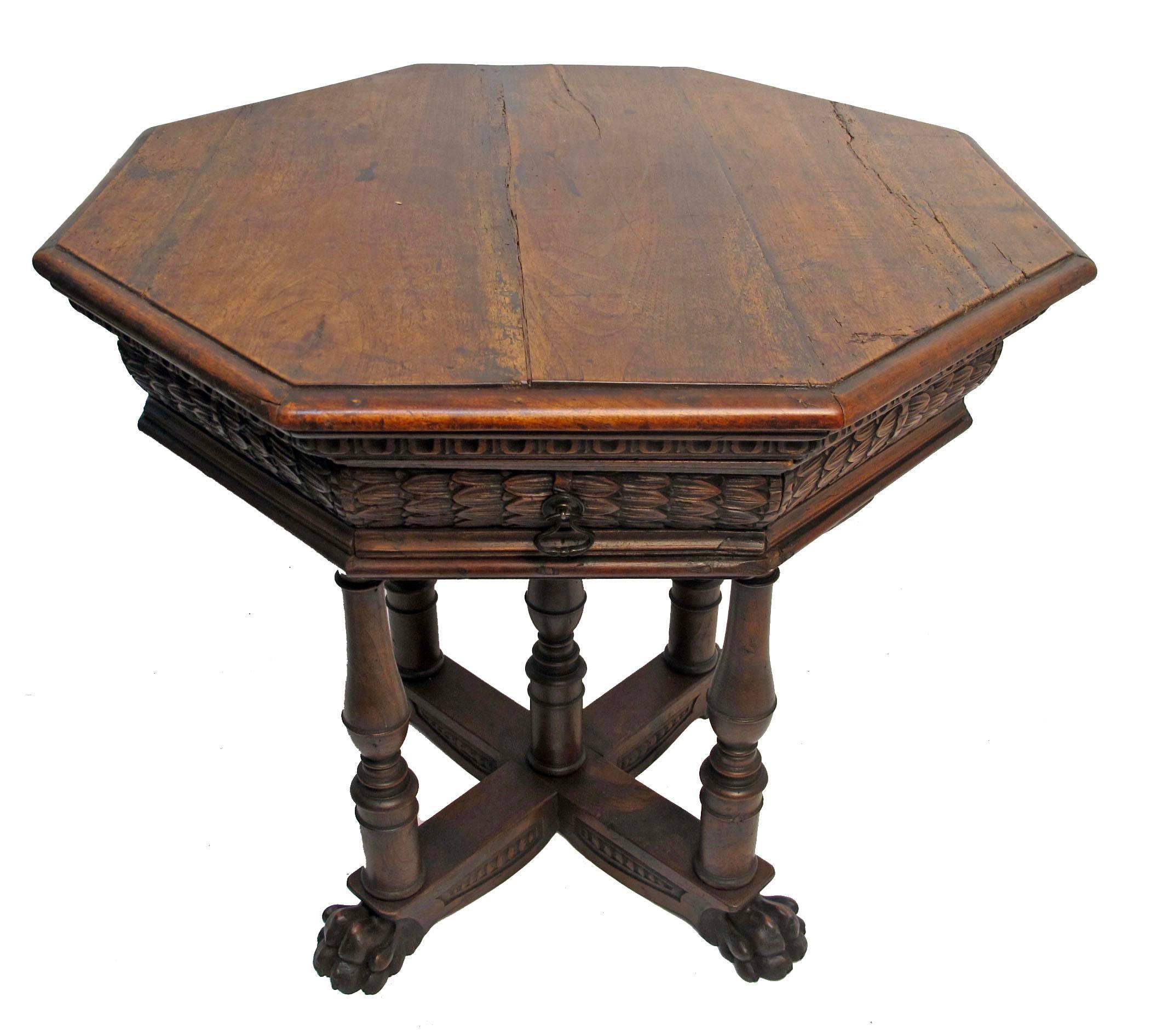 Renaissance style octagonal shape walnut centre table with a singled drawer in the elaborately carved apron, supported on four turned columns, ending on carved paw feet. Italy, circa 1850.
