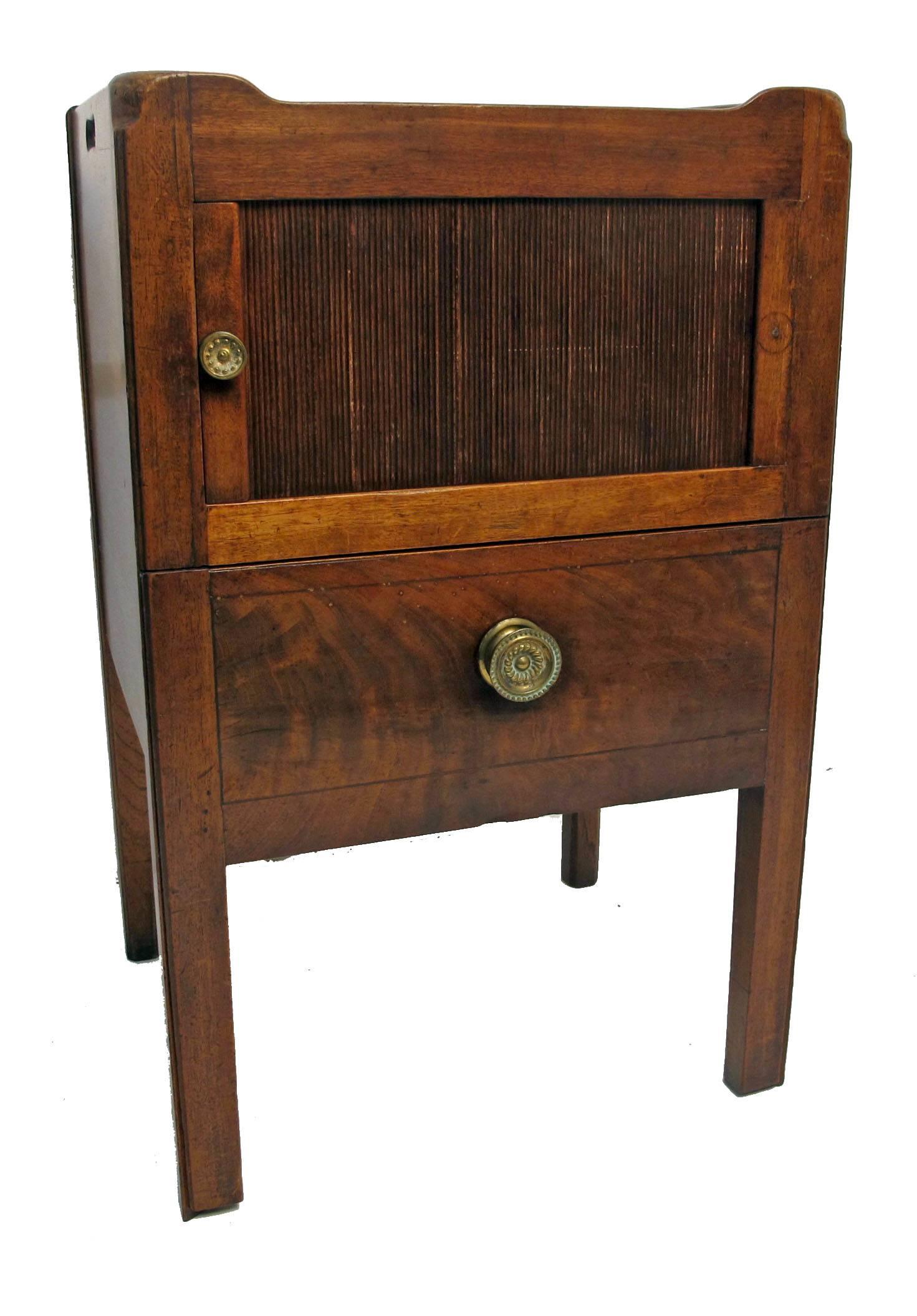 19th century mahogany gentleman's washstand bedside cabinet with wooden gallery and cut-out handles. Sliding tambour door above a single deep drawer, standing on four square legs, England, circa 1830.