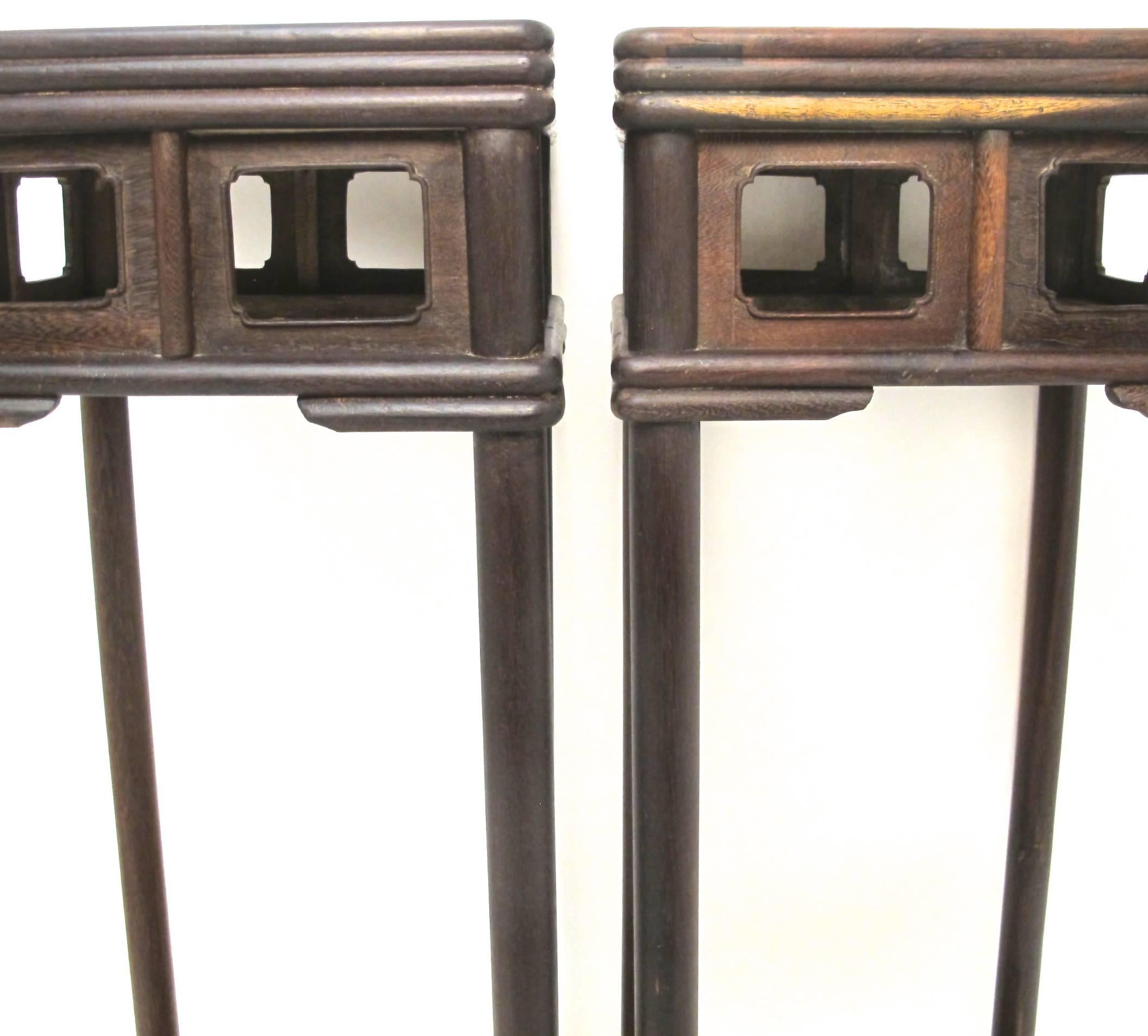 Superb pair of Jichimu (chicken wing wood) pedestals or stands with triple bull nose edge around the top and an open panel apron supported on solid round legs leading down to open fret work lower shelf, Chinese, circa 1880.
        