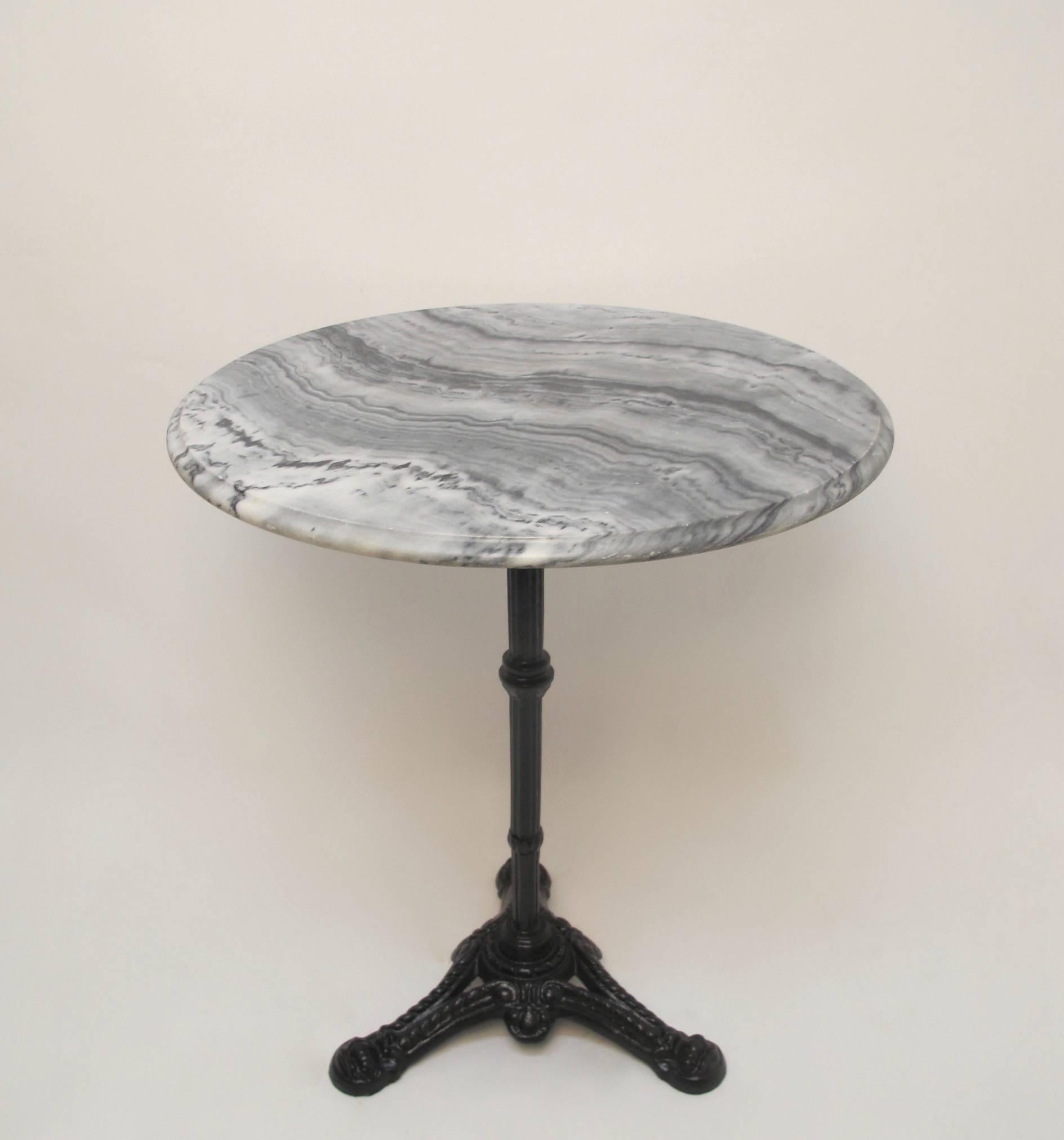 Bistro or cafe table with white and gray marble top, the cast iron base having fluted rod support on tripartite base with rope and knot legs. France, circa 1930s.