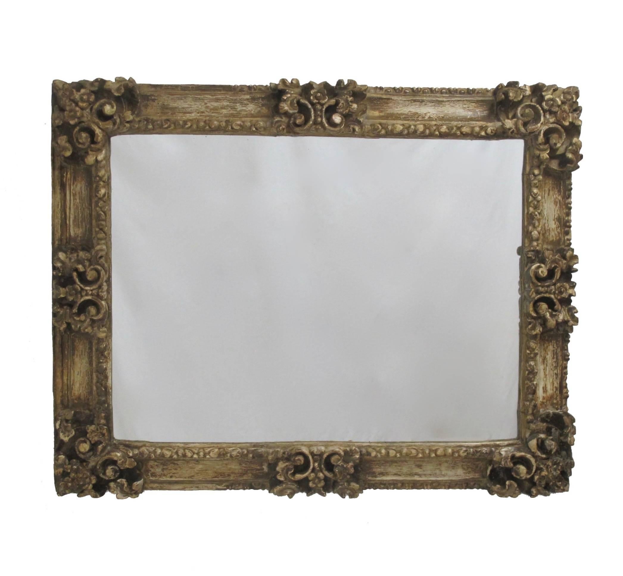 Partially stripped portrait frame made of pine. Heavily carved with leaves and flowers, and having remnants of old gilt paint. Converted into a mirror in the early 20th century. Spain, circa 1800.