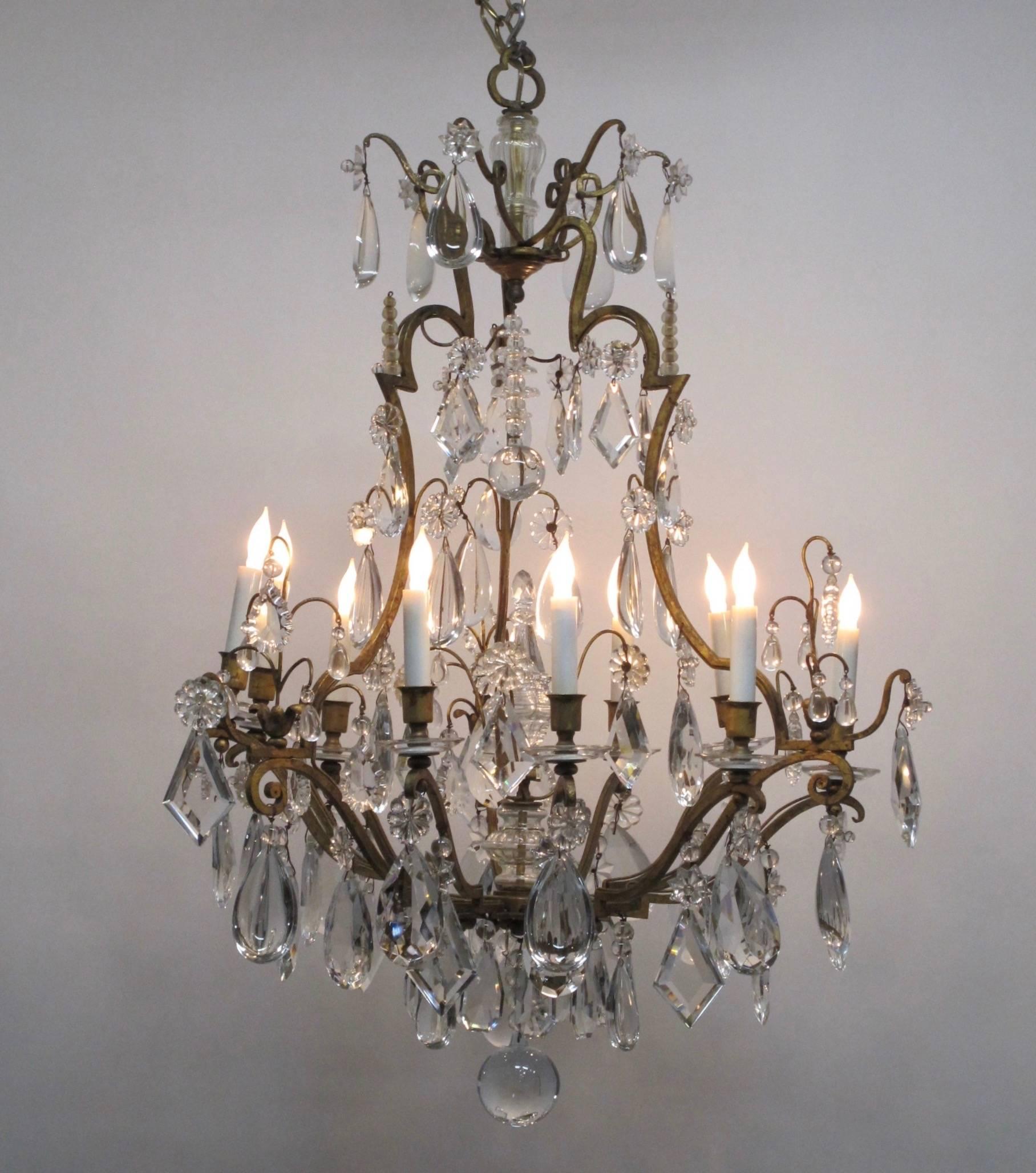 Handsome, pear shape gilt iron and crystal chandelier. The nine lights grouped into three sets of three. Iron frame hung with chunky crystals. Recently rewired and brass ceiling canopy provided.
