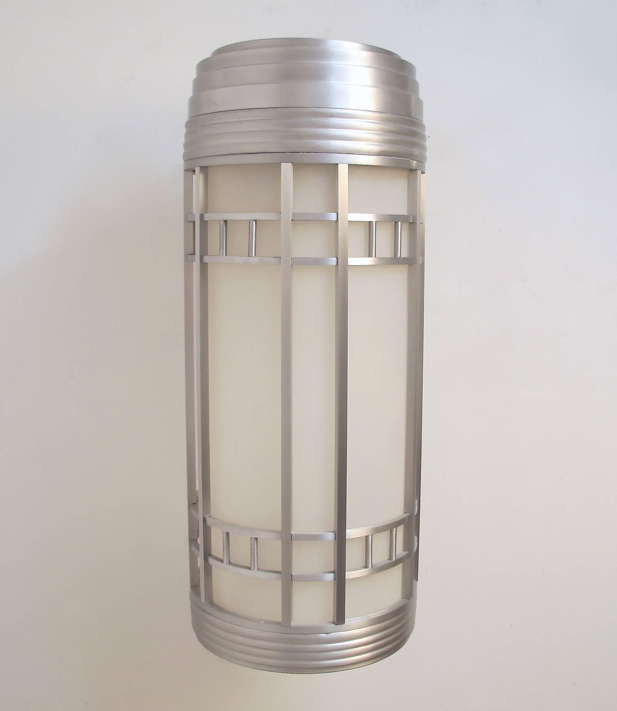 Commercial size Art Deco or Streamlined Moderne style lantern wall sconces. Aluminum body with opaque white lexan insert. Light fixtures have been completely reconditioned and re-wired. American, 1930s-1940s.