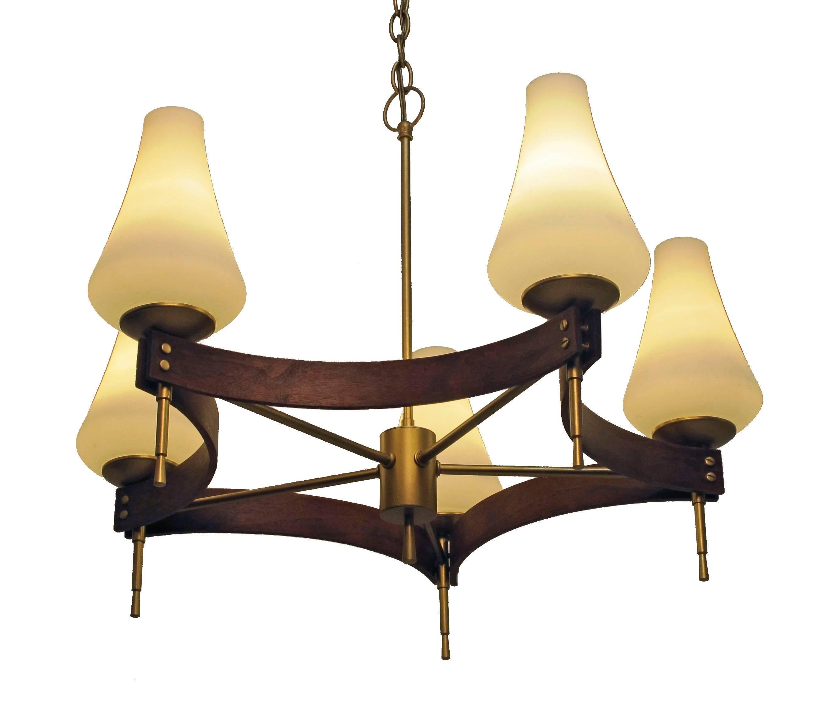 Brushed Brass and Walnut Mid Century five light chandelier with frosted white glass shades sitting on brass cups.  Recently reconditioned and rewired having standard base sockets.  Length of chain can be provided for customers needs.  American,