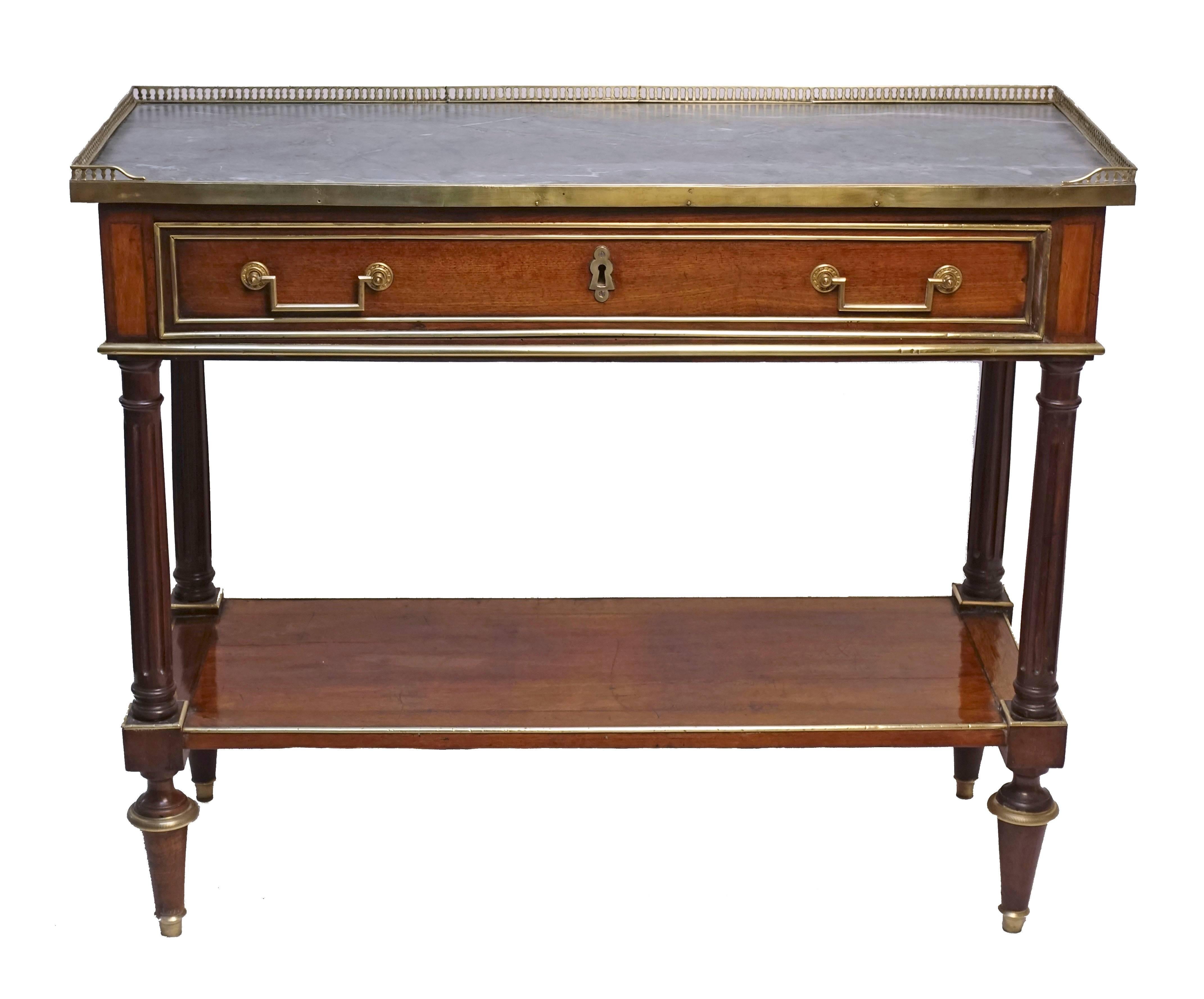 Brass-mounted Directoire period dessert table or server with brass gallery around the grey and white marble top above a single drawer. Having brass recessed panels and four fluted columns connecting to a lower shelf, standing on brass adorned toupe