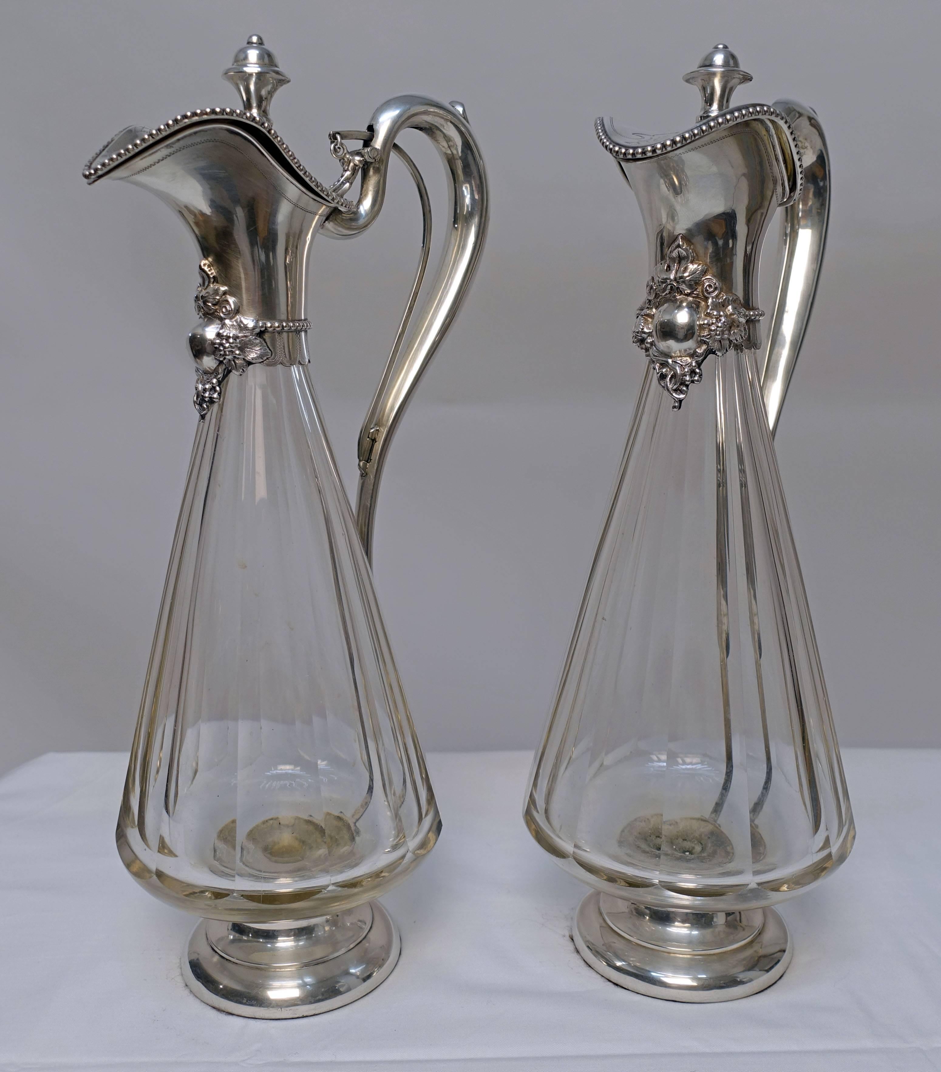 A matched pair of Art Nouveau style wine clarets or decanters, wheel cut panel glass with silver (at least 800 silver, possibly sterling). Having makers mark on the lid. Continental European (possibly France), 19th century, circa 1890.