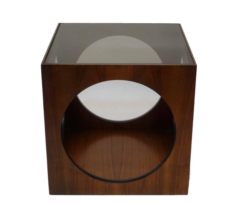 Black walnut geometric cube table with inset smoked glass top and circle cut outs, having an ebonized edge around each circle, American, mid-20th century, circa 1970s.