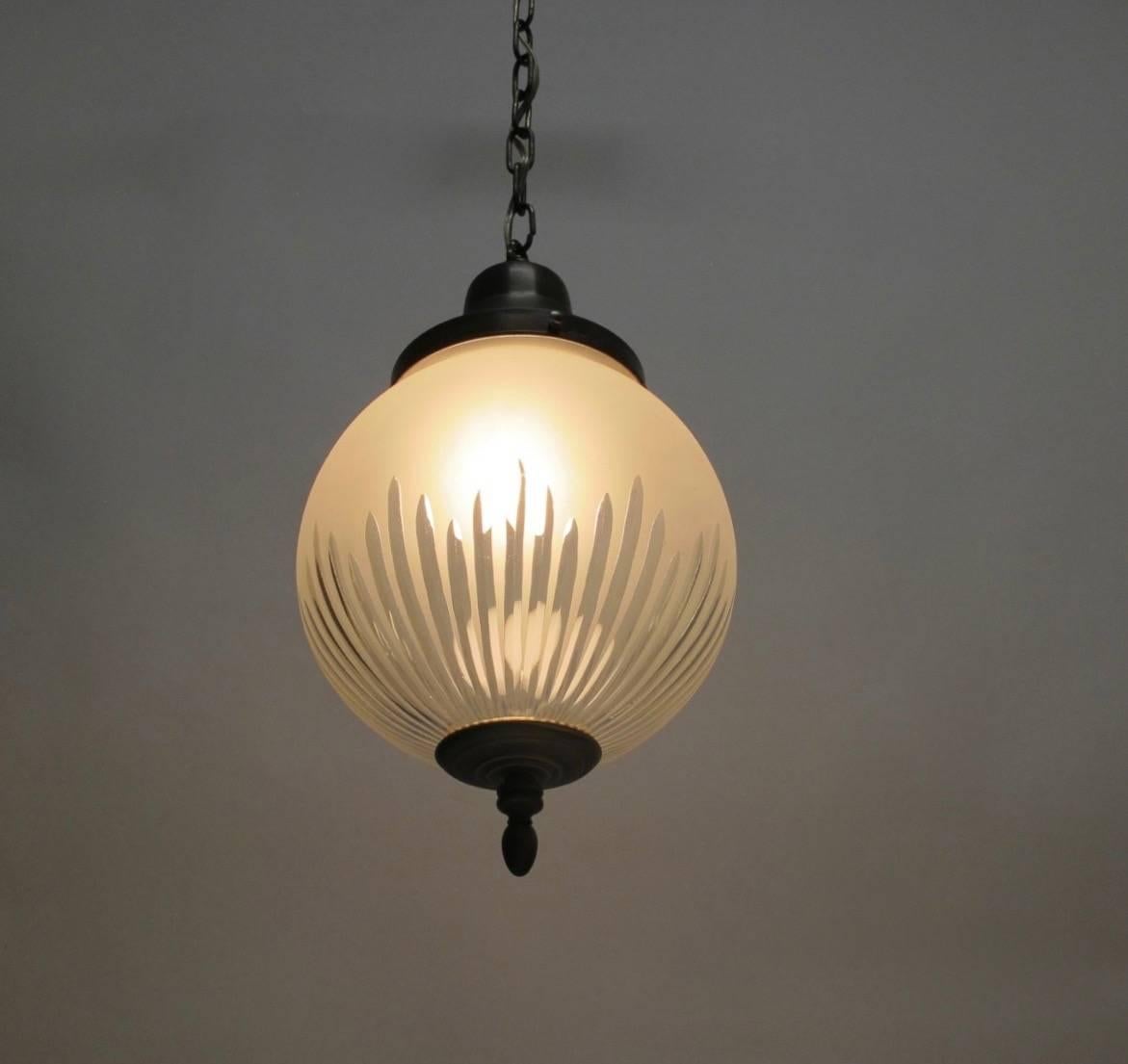 Hanging frosted and cut glass pendant orb light fixture with a single bulb having patinated bronze finish on the fittings and with a bronze finished canopy. Newly re-wired, chain can be adjusted to desired length. American, early 20th century.
