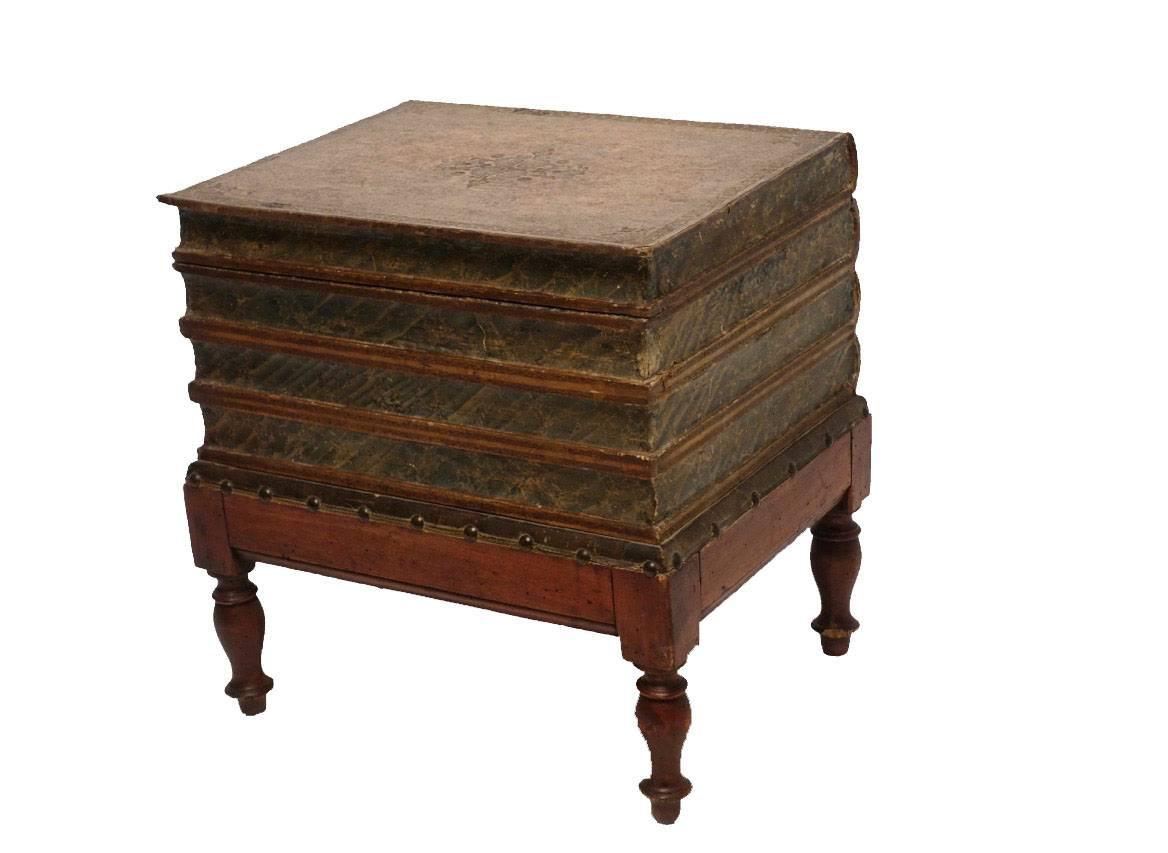 Leather four volume faux book box on painted pine stand with turned legs. Interior of the box lined with Italian marbleized paper and having a small lidded compartment within. England, circa 1830.