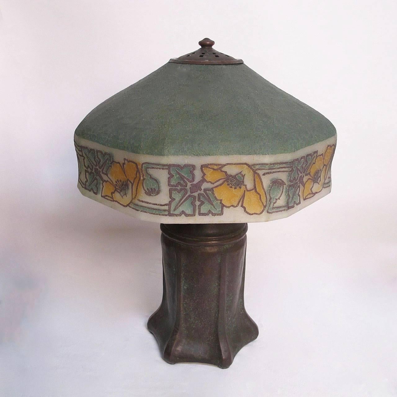 Arts and Craft period Handel table lamp. Having the original reverse painted glass shade, marked on the bronzed patinated metal base and on the metal fittings on the shade. Recently re-wired, holds three standard size light bulbs. The measurements