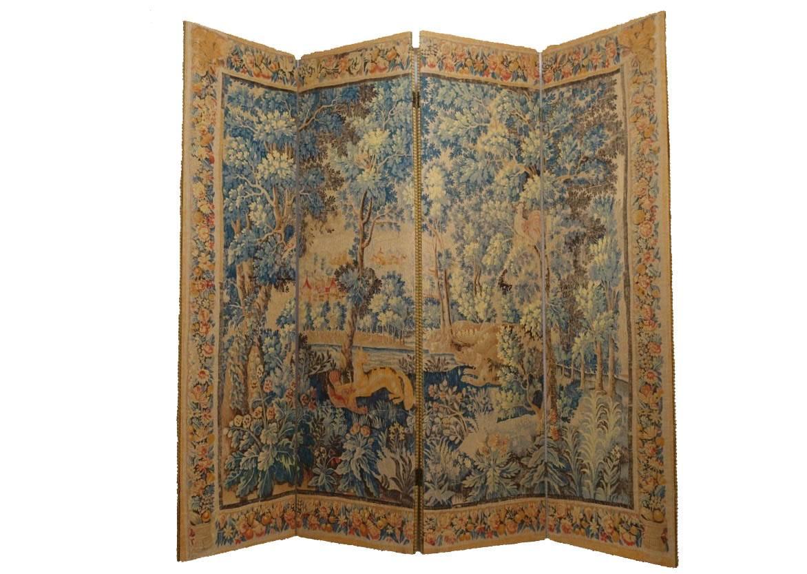 A four-panel printed tapestry style screen or wall decoration with brass bifold hinges.