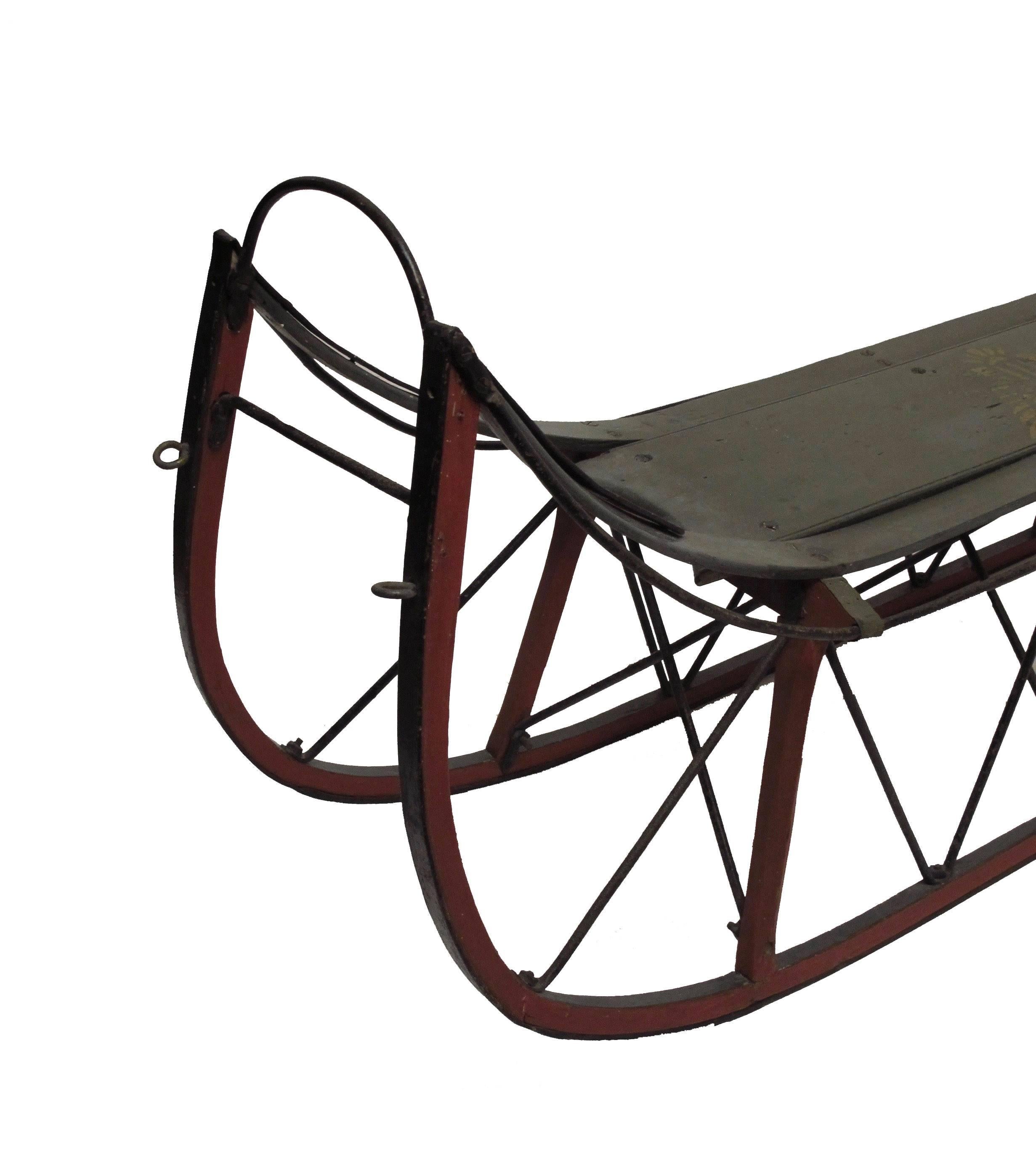 Charming old wood sled with hand wrought  iron frame. Having most of its original red and green paint (there is a small amount of overpainting). Seat height of this sled is 13 inches. This would make and unusual and interesting coffee table,