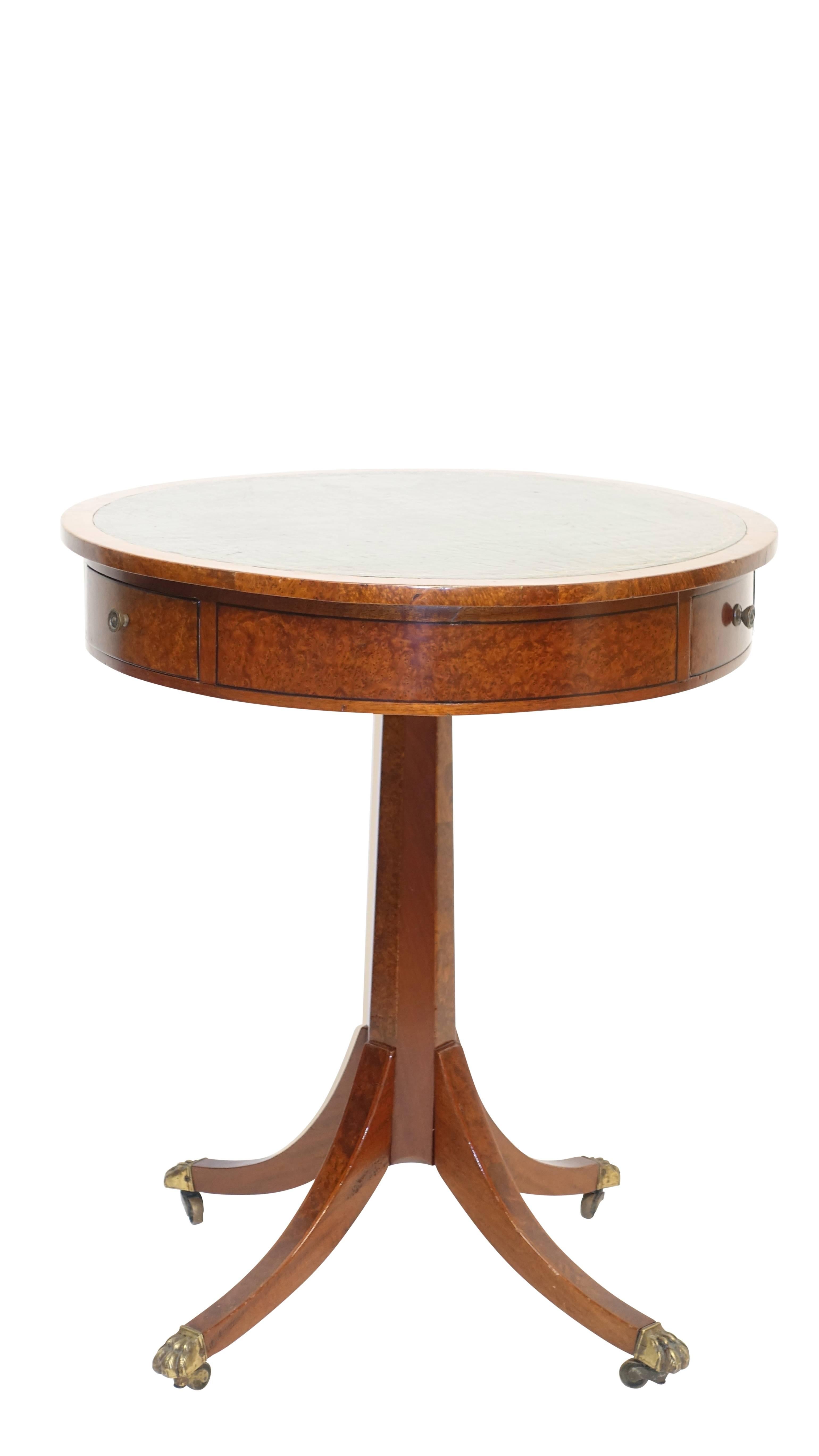 An unusual handmade Georgian style mahogany pedestal table with inset green leather surface. Having a revolving top with three short drawers set into the burled apron, standing on a single pedestal with splayed legs ending in brass lion paw feet