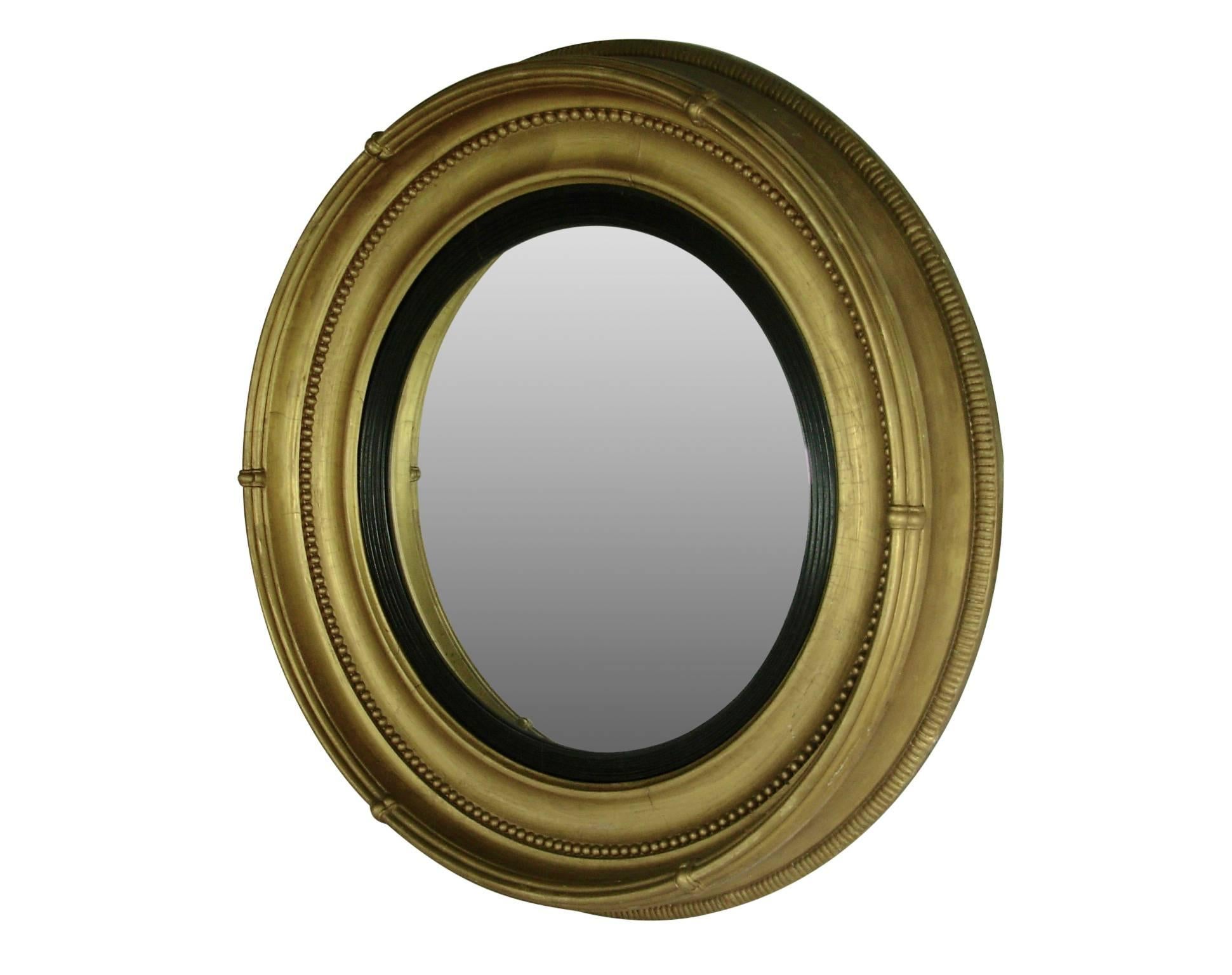 A large-scale Regency style giltwood convex mirror. Old mirror shows some light clouding and spotting. England, mid-19th century.