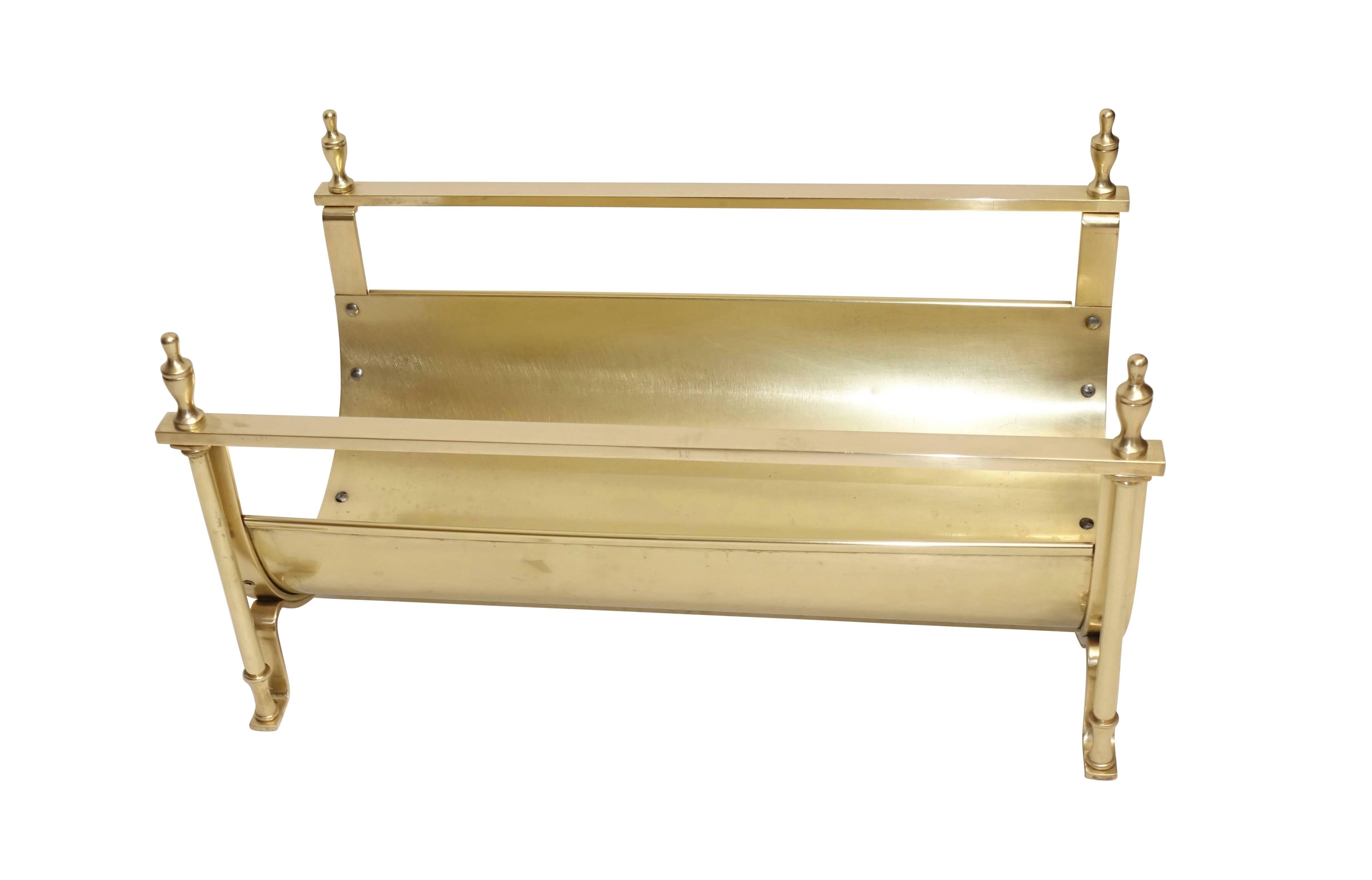 For the fireplace a brass log holder in the neoclassical style with urn shape finials, American, early 20th century.