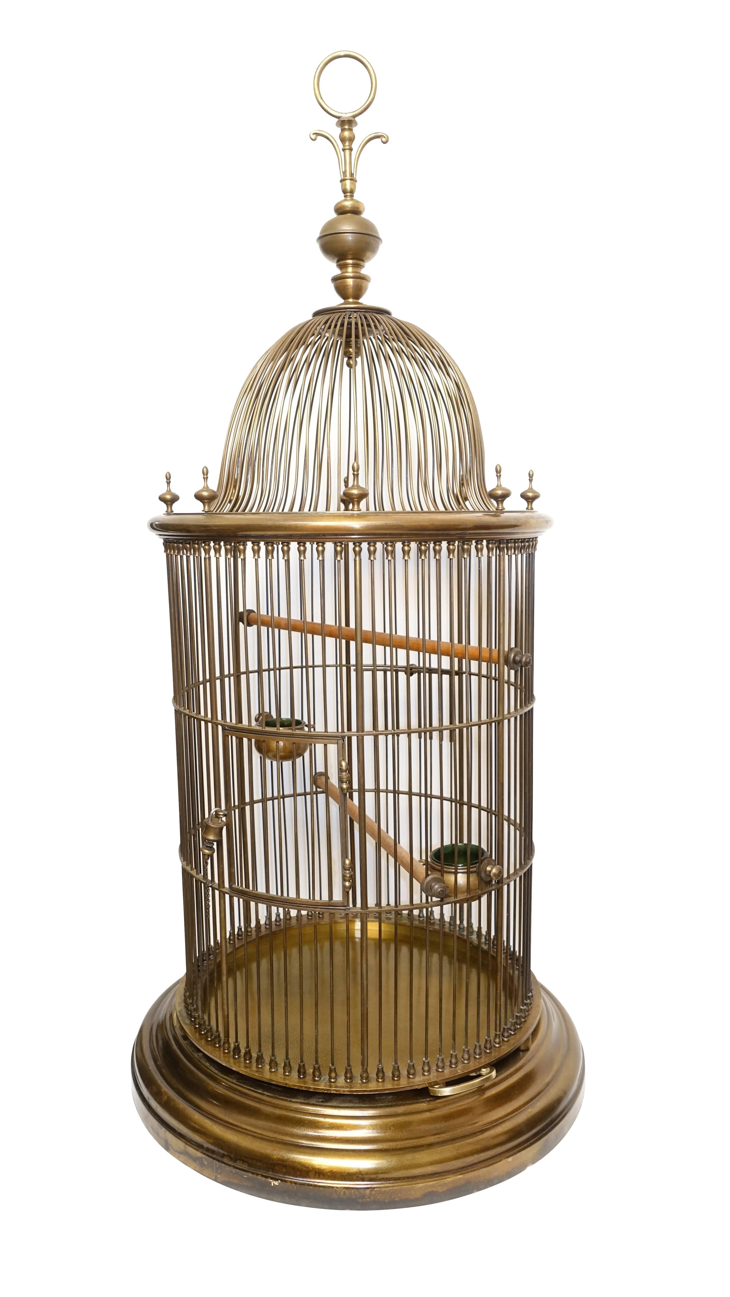 Spectacular and large solid bronze bird cage complete with green glass lined bronze feeders and with two perching rods, both rods and feeders are adjustable. Having original bronze keyed lock and a separate opening for feeding. The interior